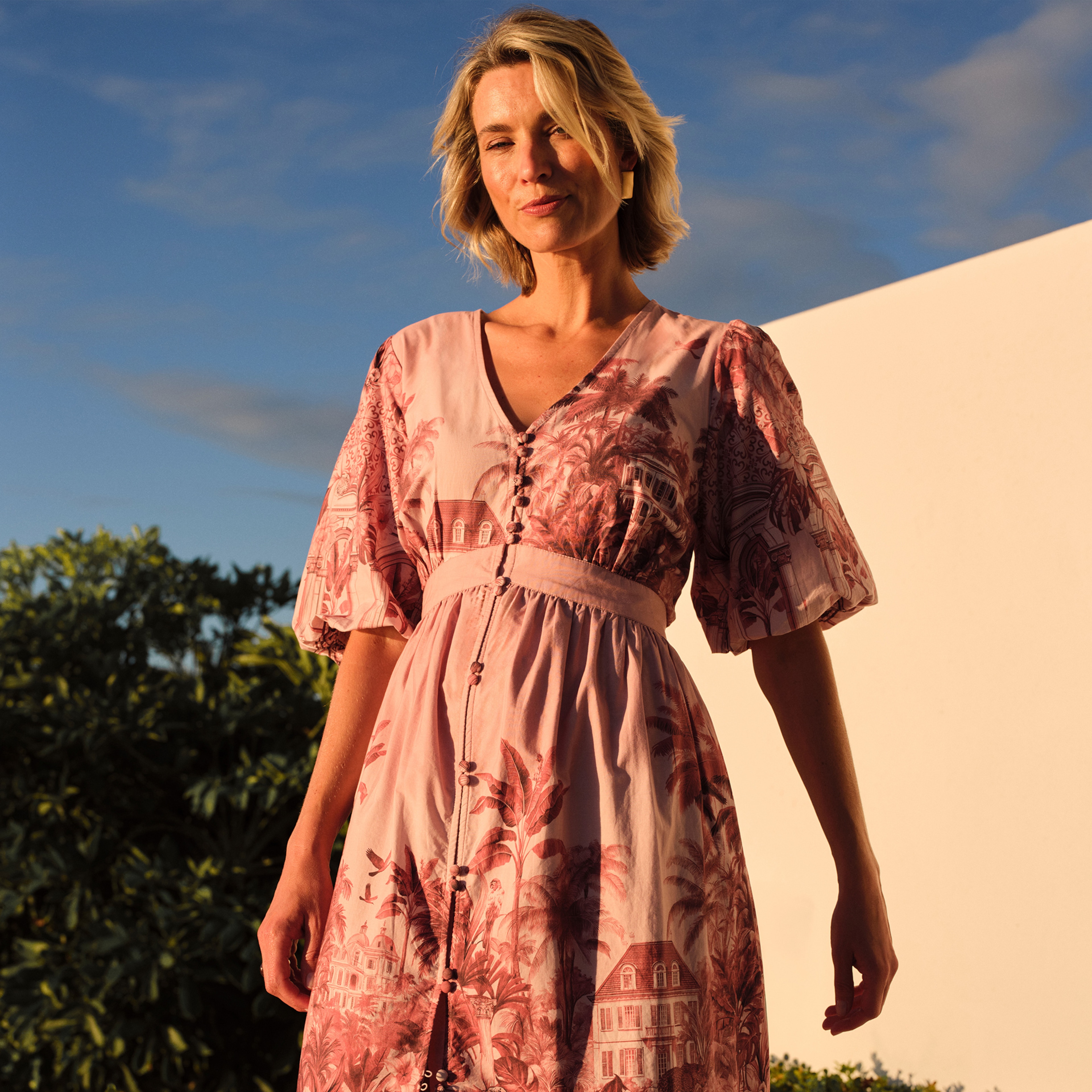 A lady wearing a pink print patterned dress.