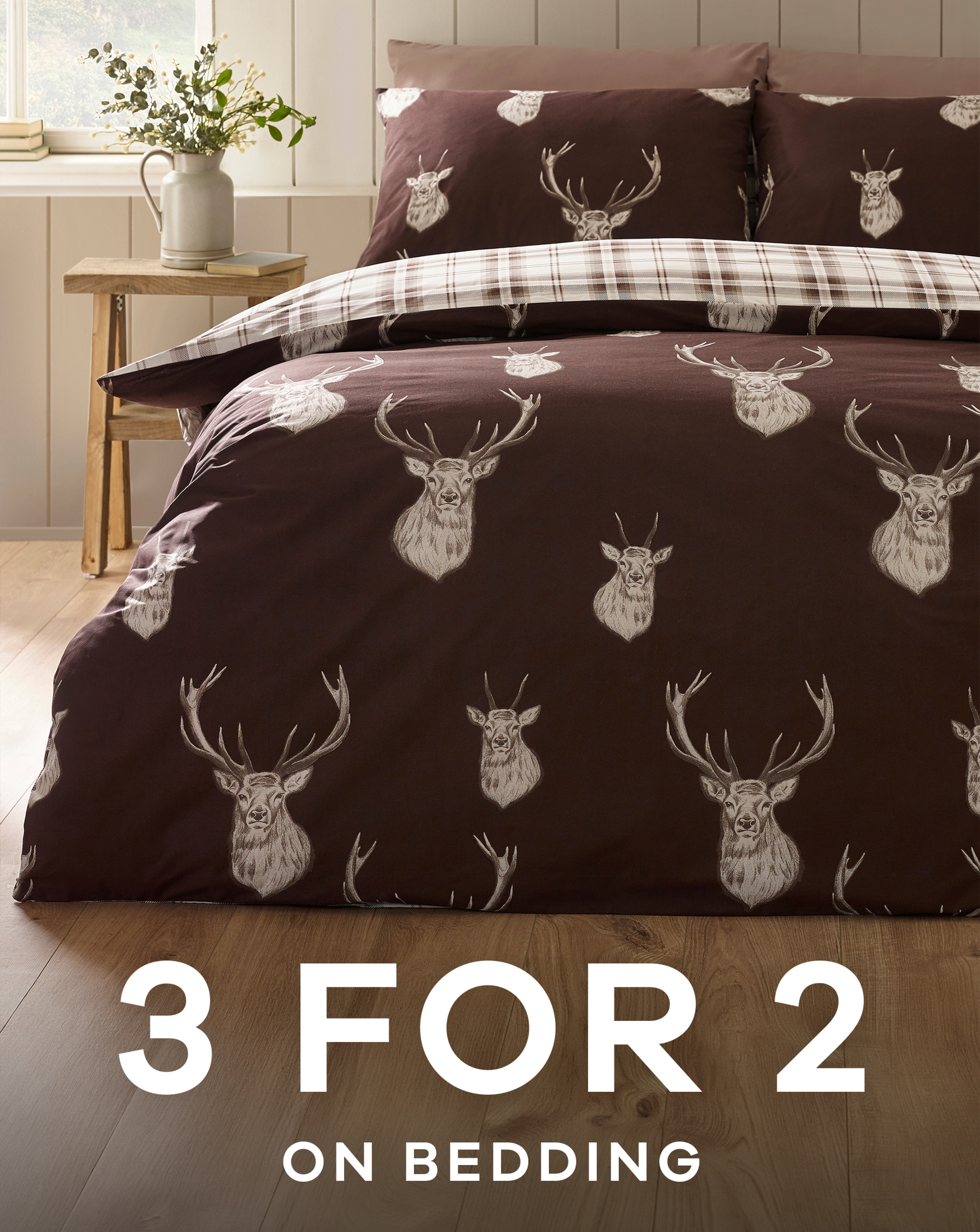 A brown bedding set with Reindeer heads on it spaced out.