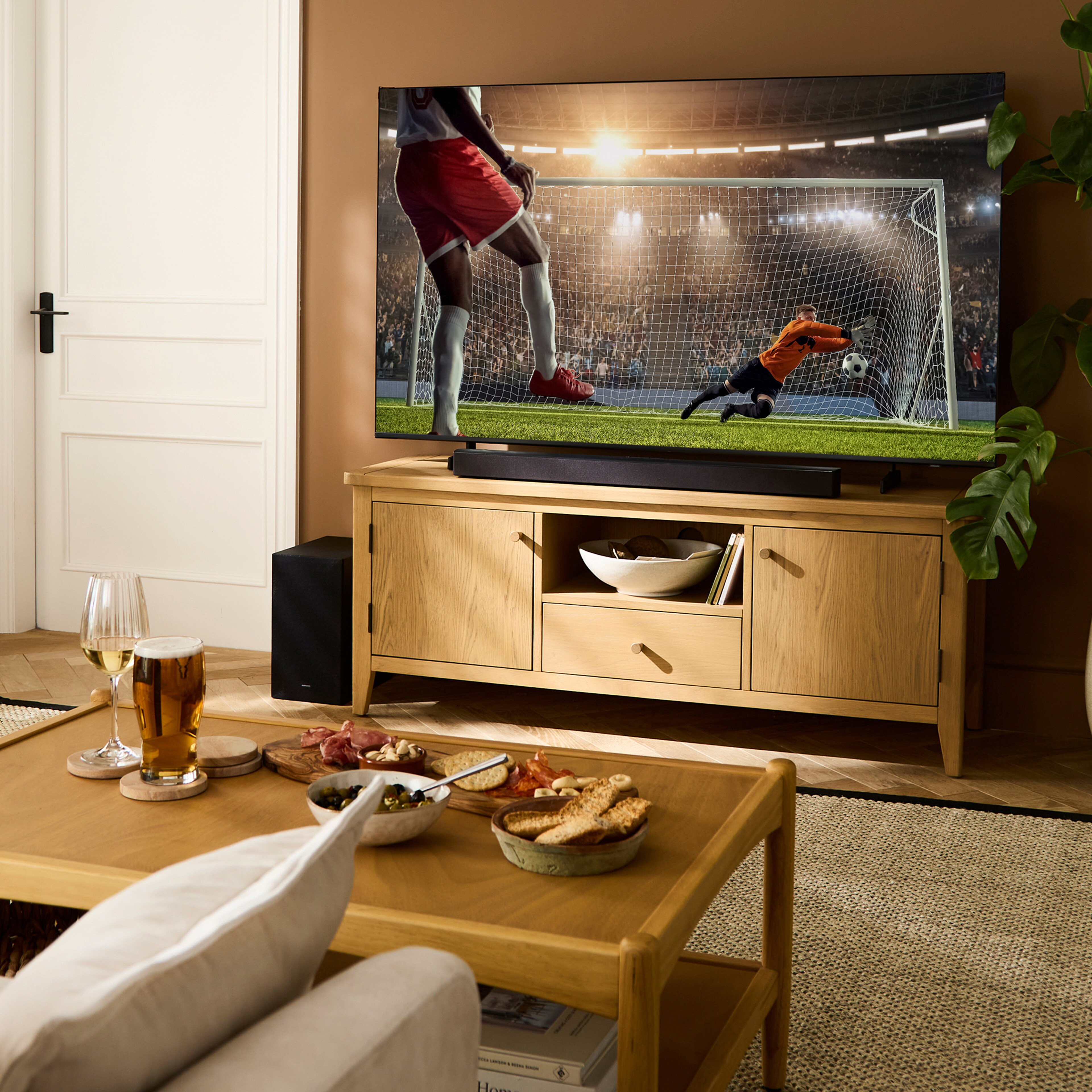 A living room with TV showing a game of football.