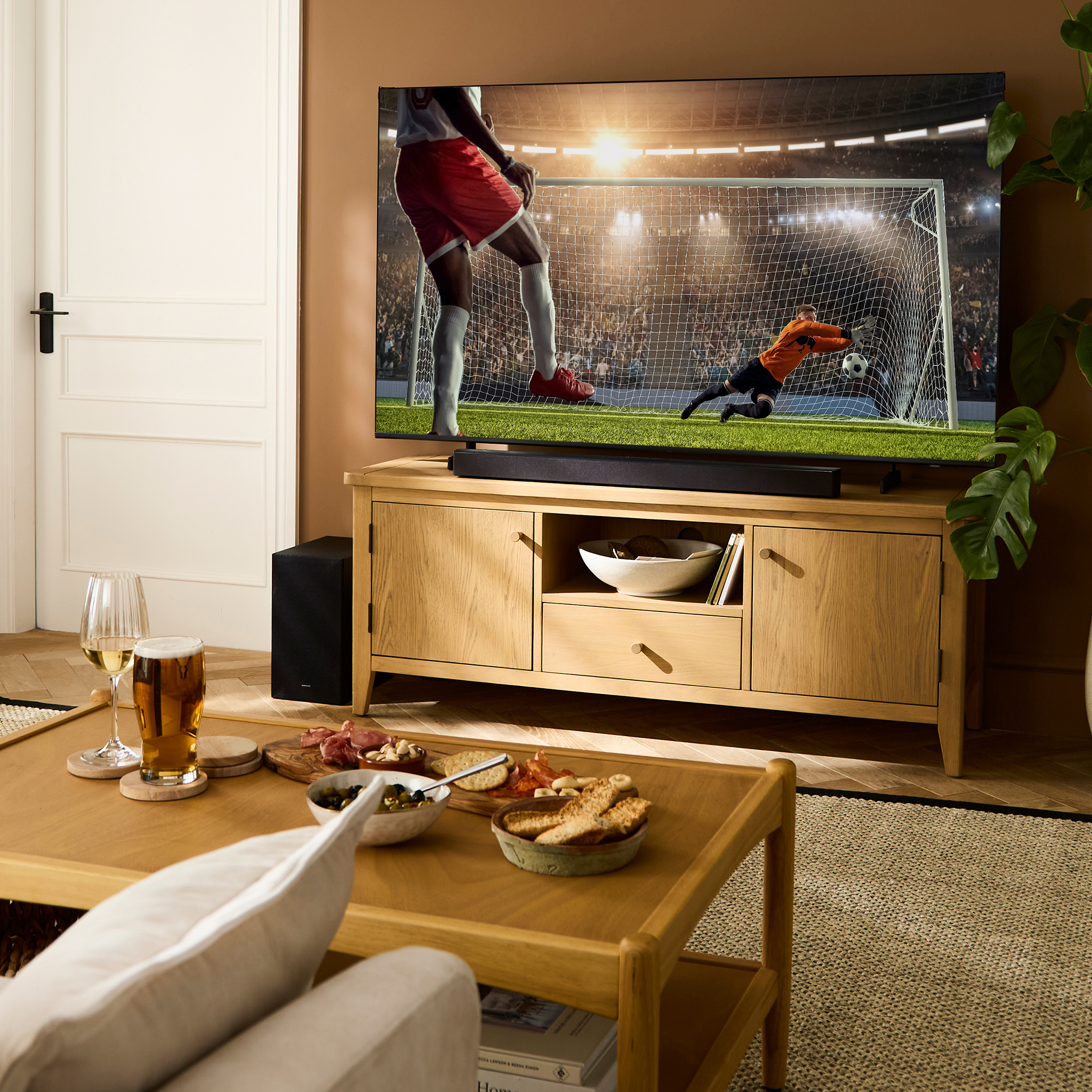 A living room with TV showing a game of football.