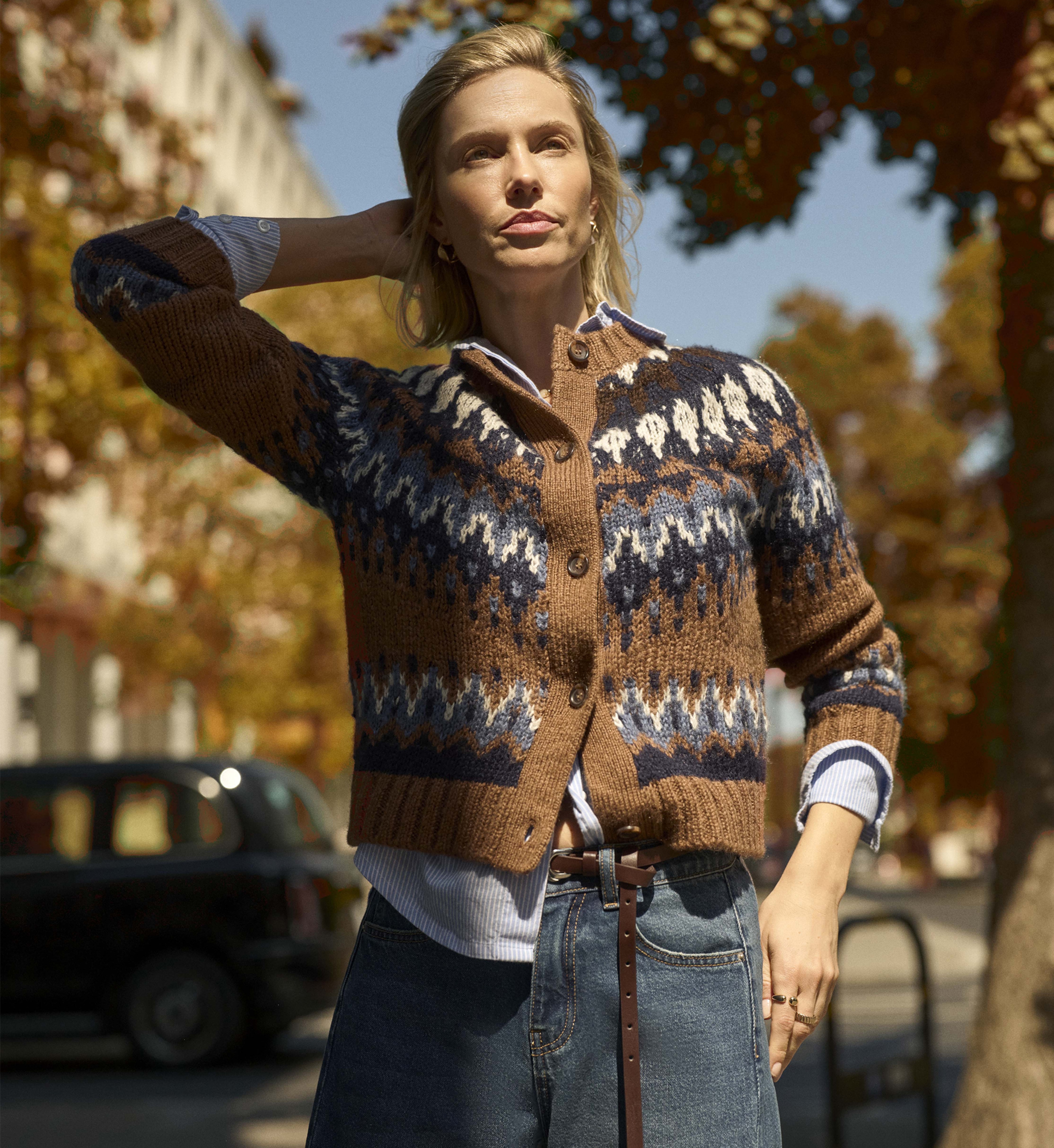 A woman stood outside wearing a patterned knitted cardigan.