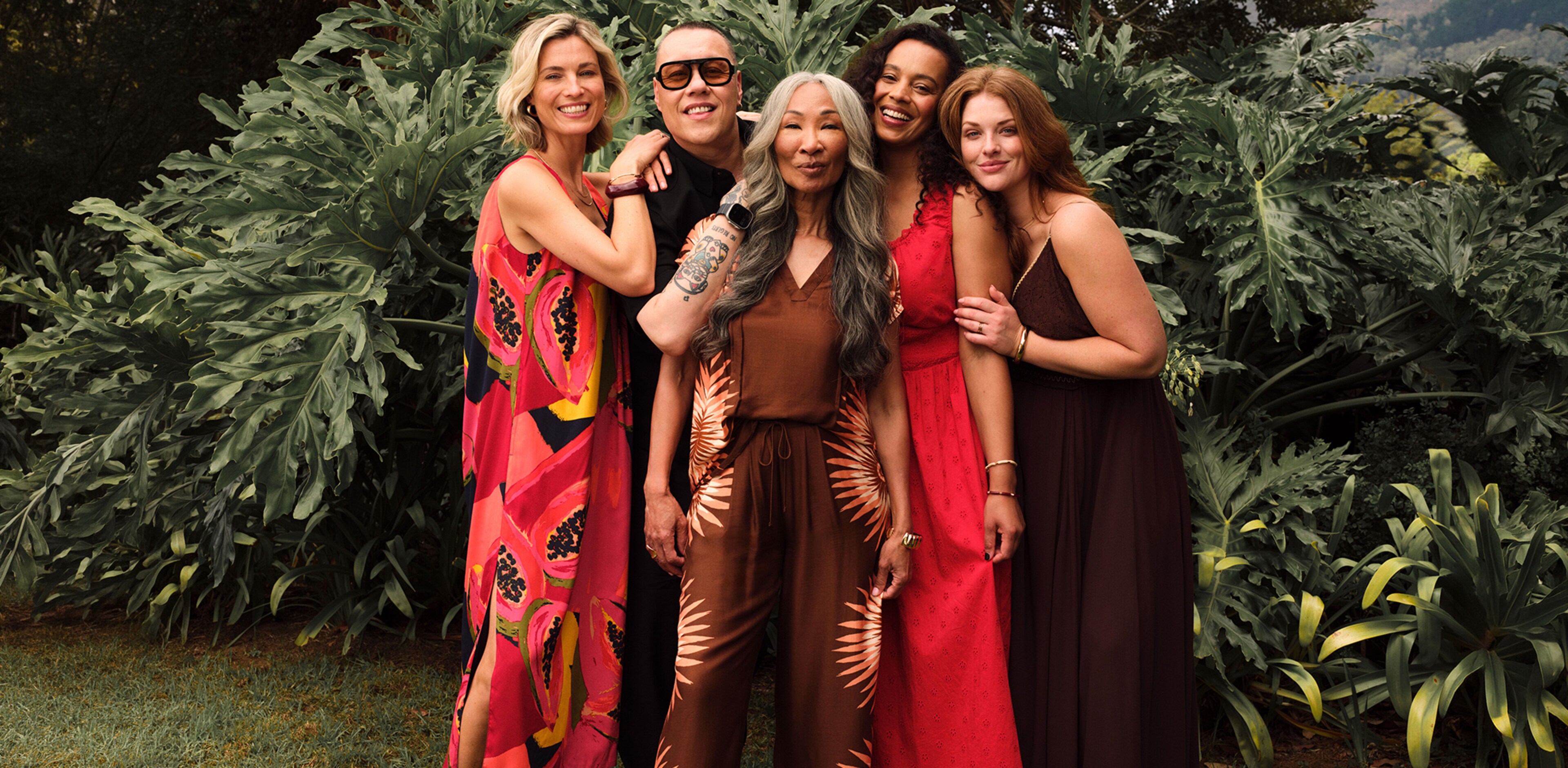 A group of ladies and Gok Wan stood in front of some plants outside in a garden.