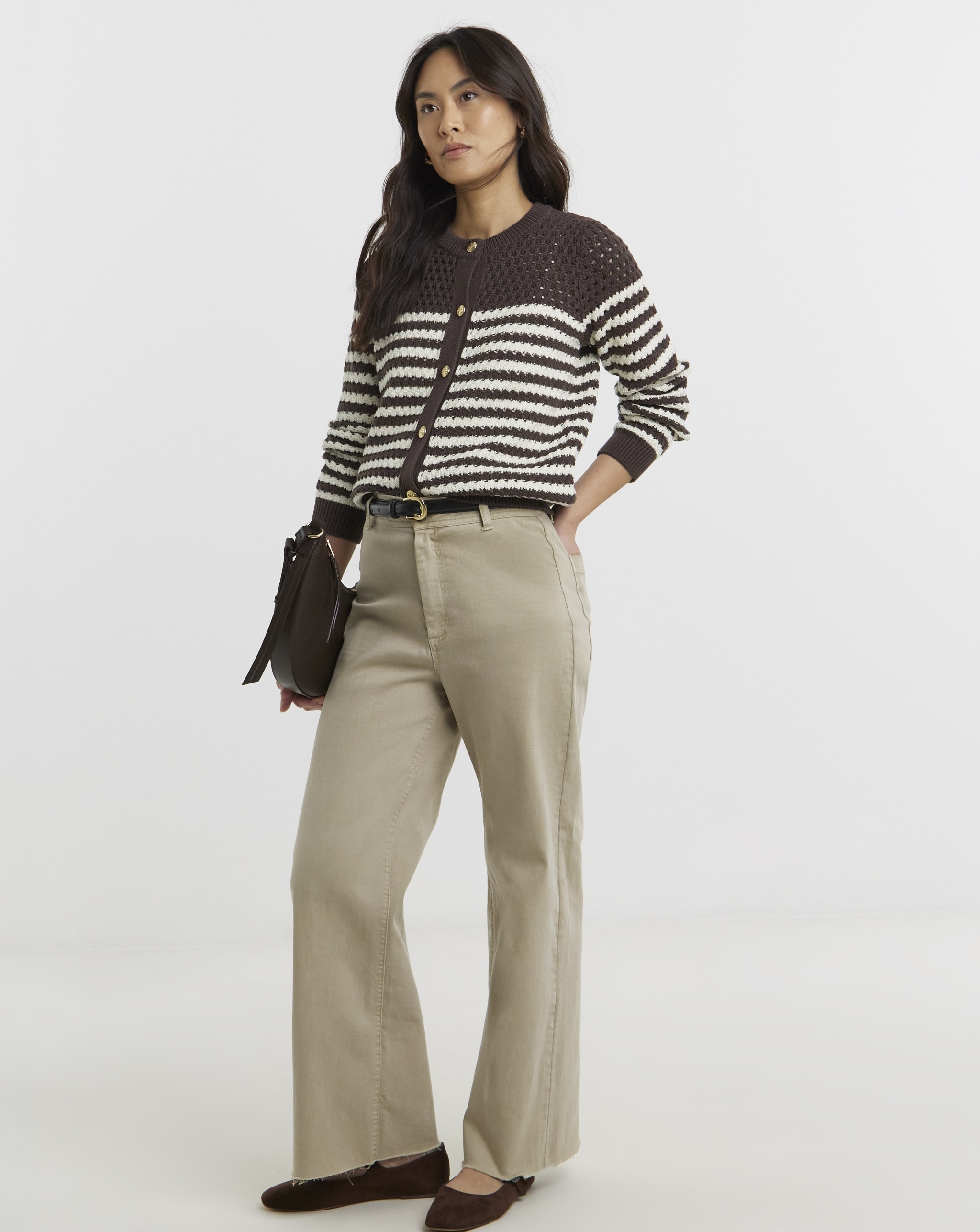Woman wearing brown stripped cardigan and beige trousers