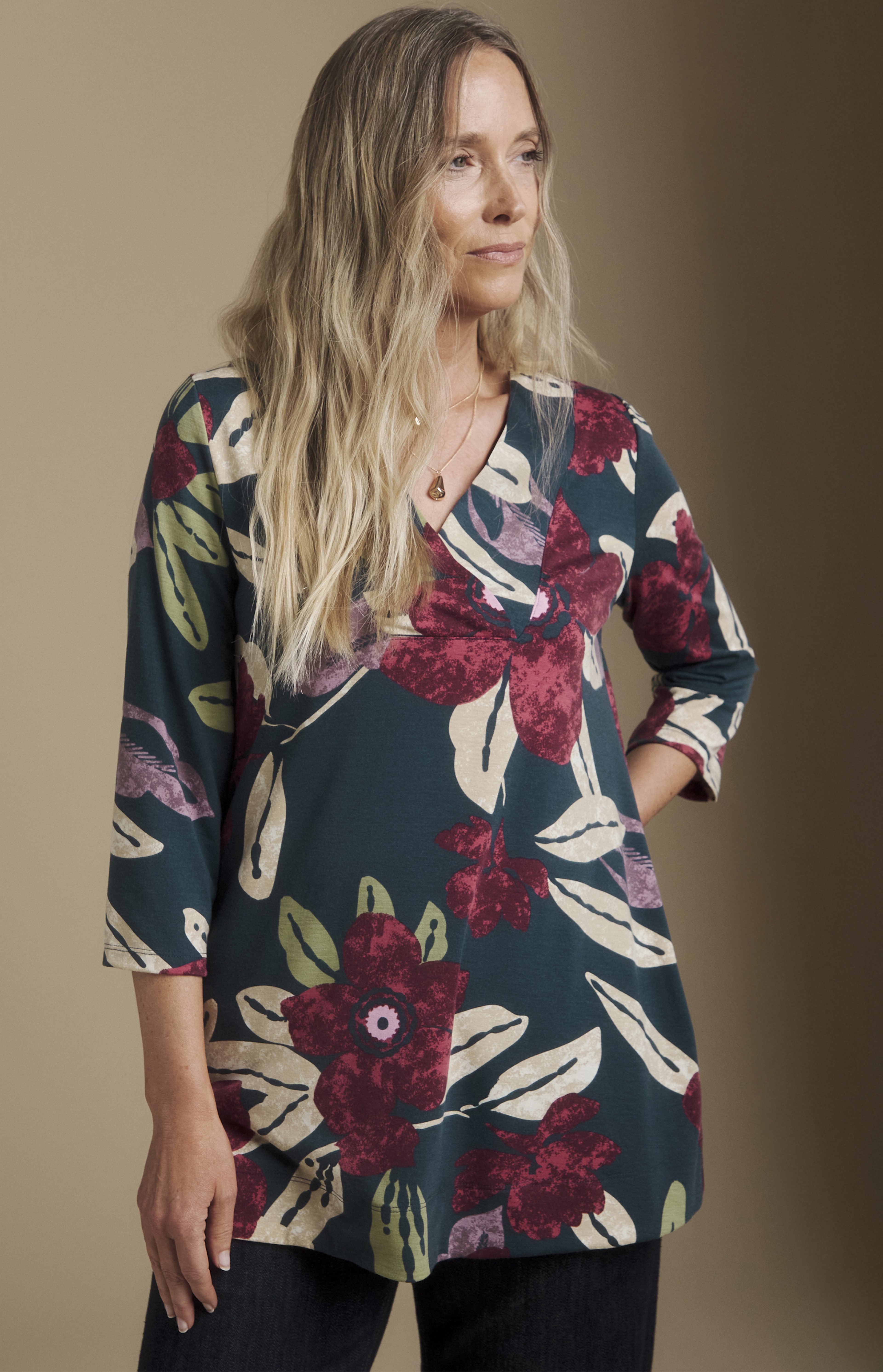 A woman wearing a teal floral printed tunic.