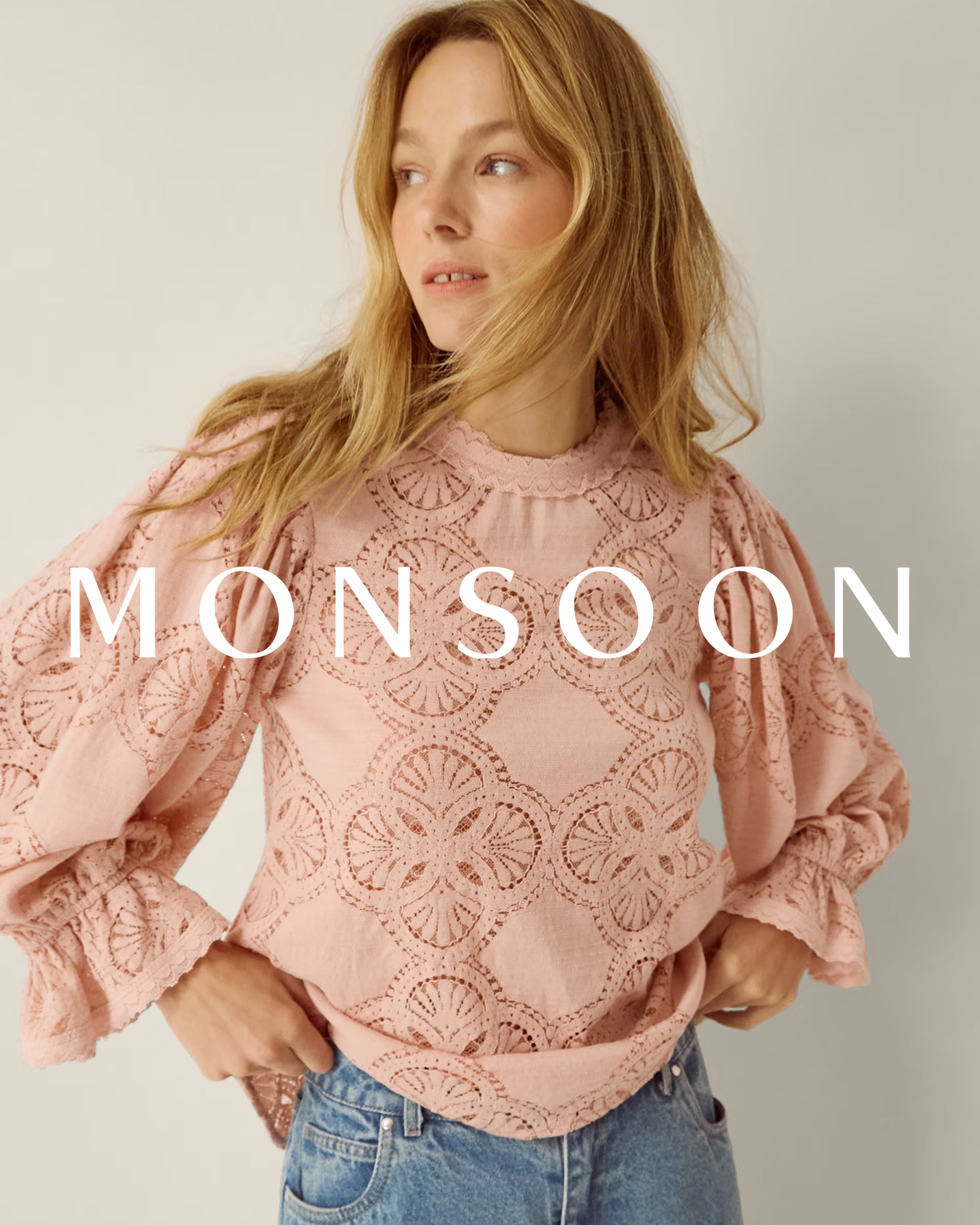 A woman wearing a soft pink embroidered Monsoon jumper.