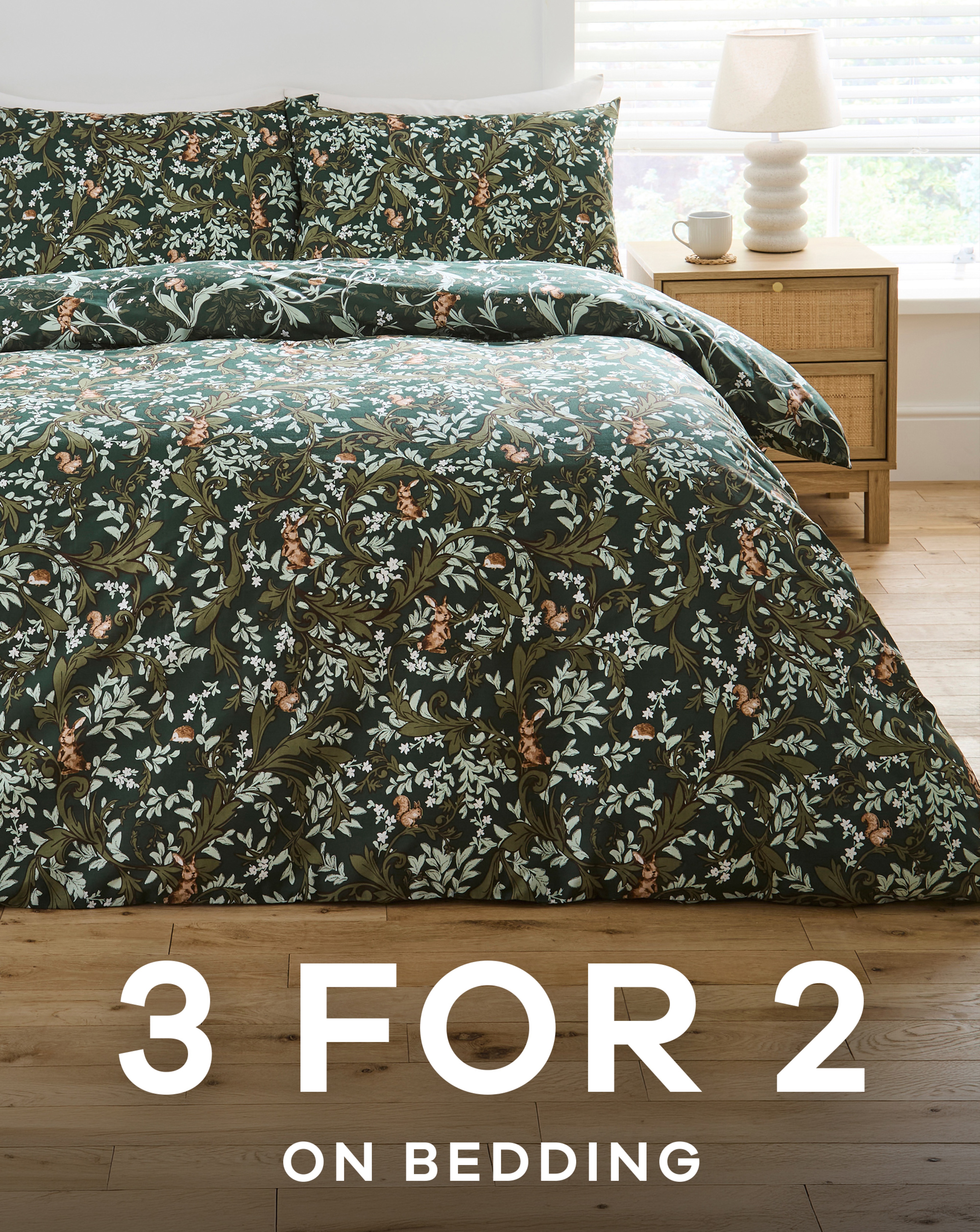 A bed made up in forest leaf patterned green bedding.