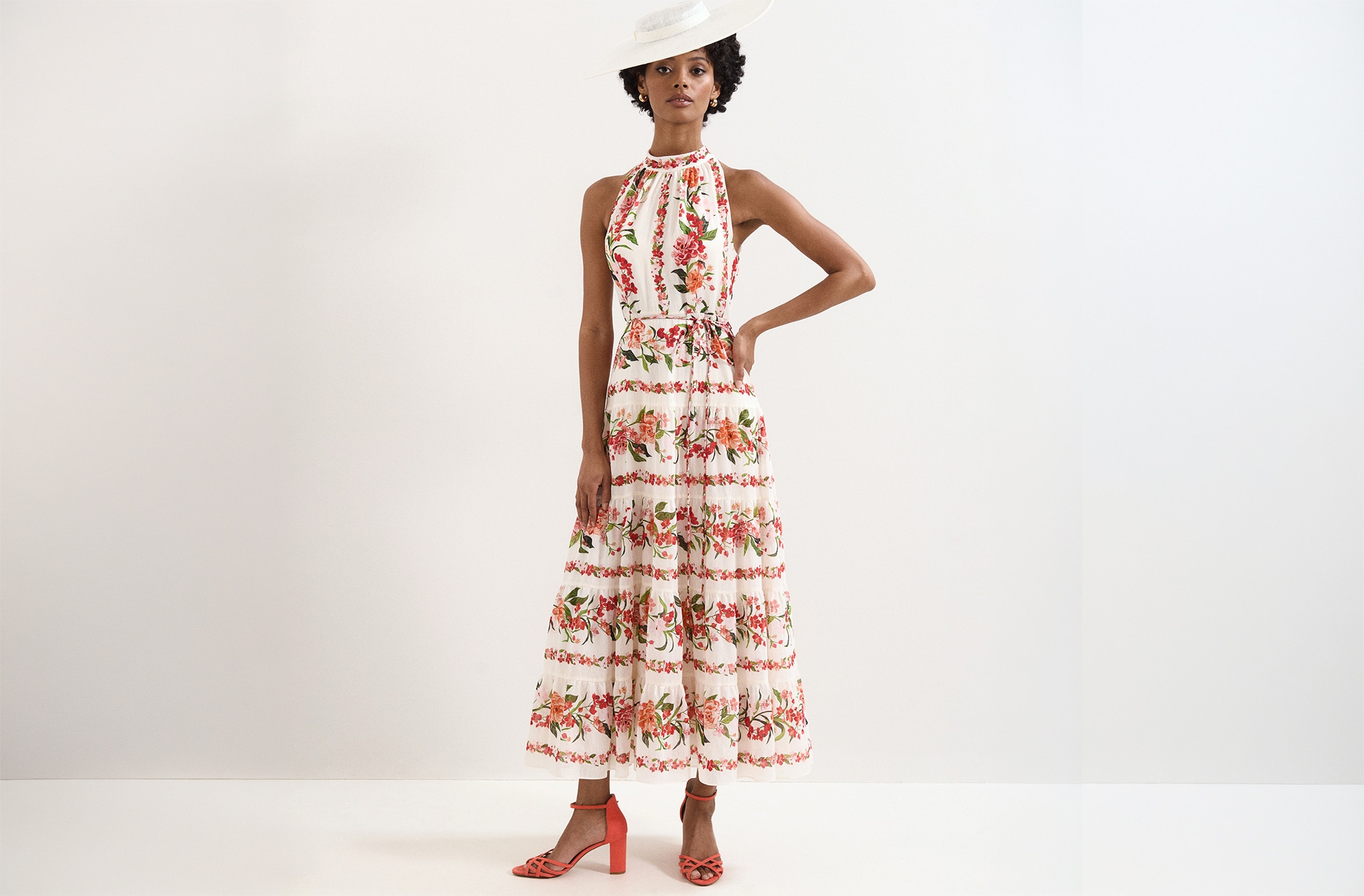 A woman wearing a sleeveless floral dress.