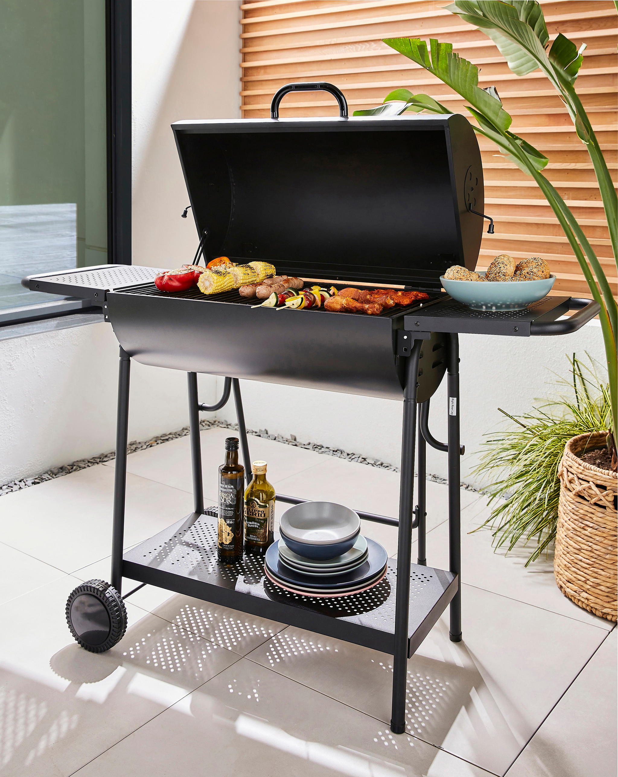 A black barrel shaped BBQ set