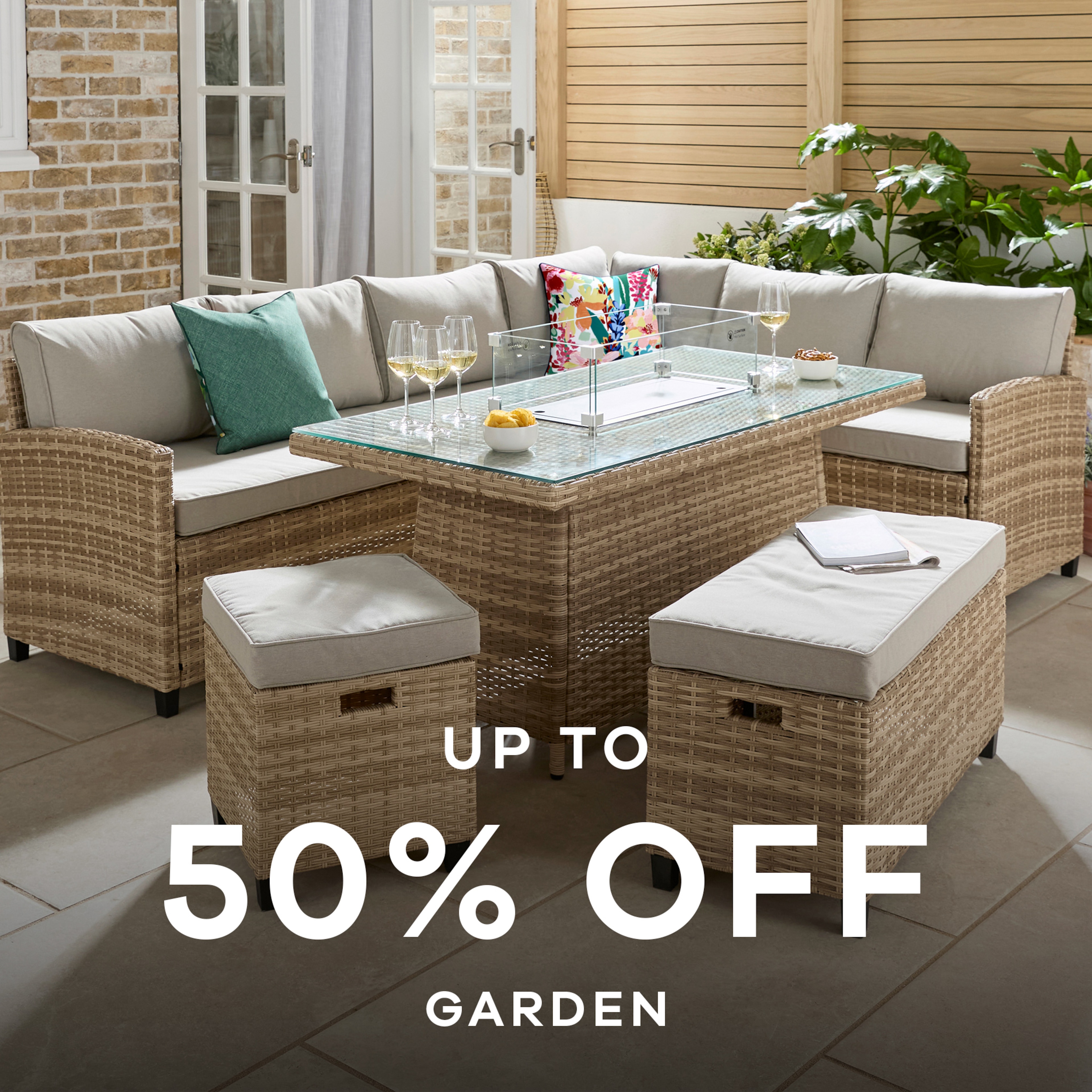 A light brown coloured rattan garden set with stone coloured cushions.