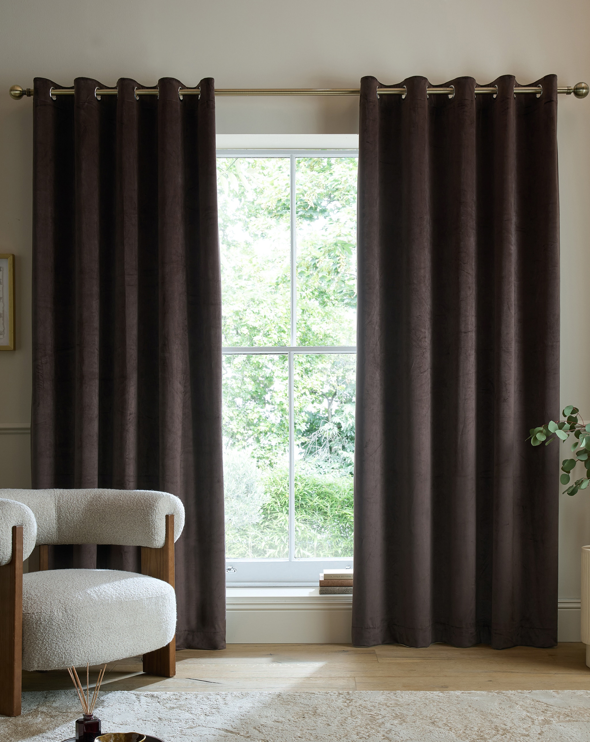 A room with dark brown floor to ceiling thermal insulated curtains.