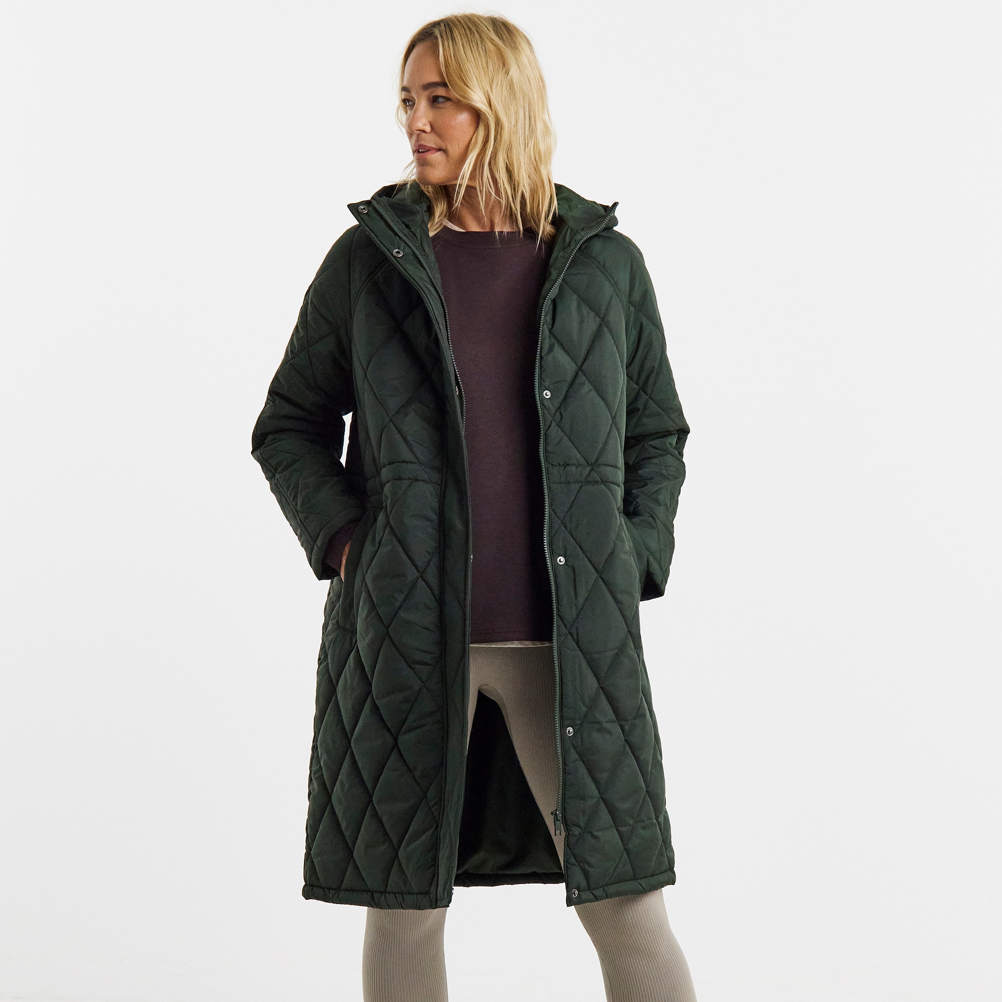 A woman stood wearing a green quilted coat.