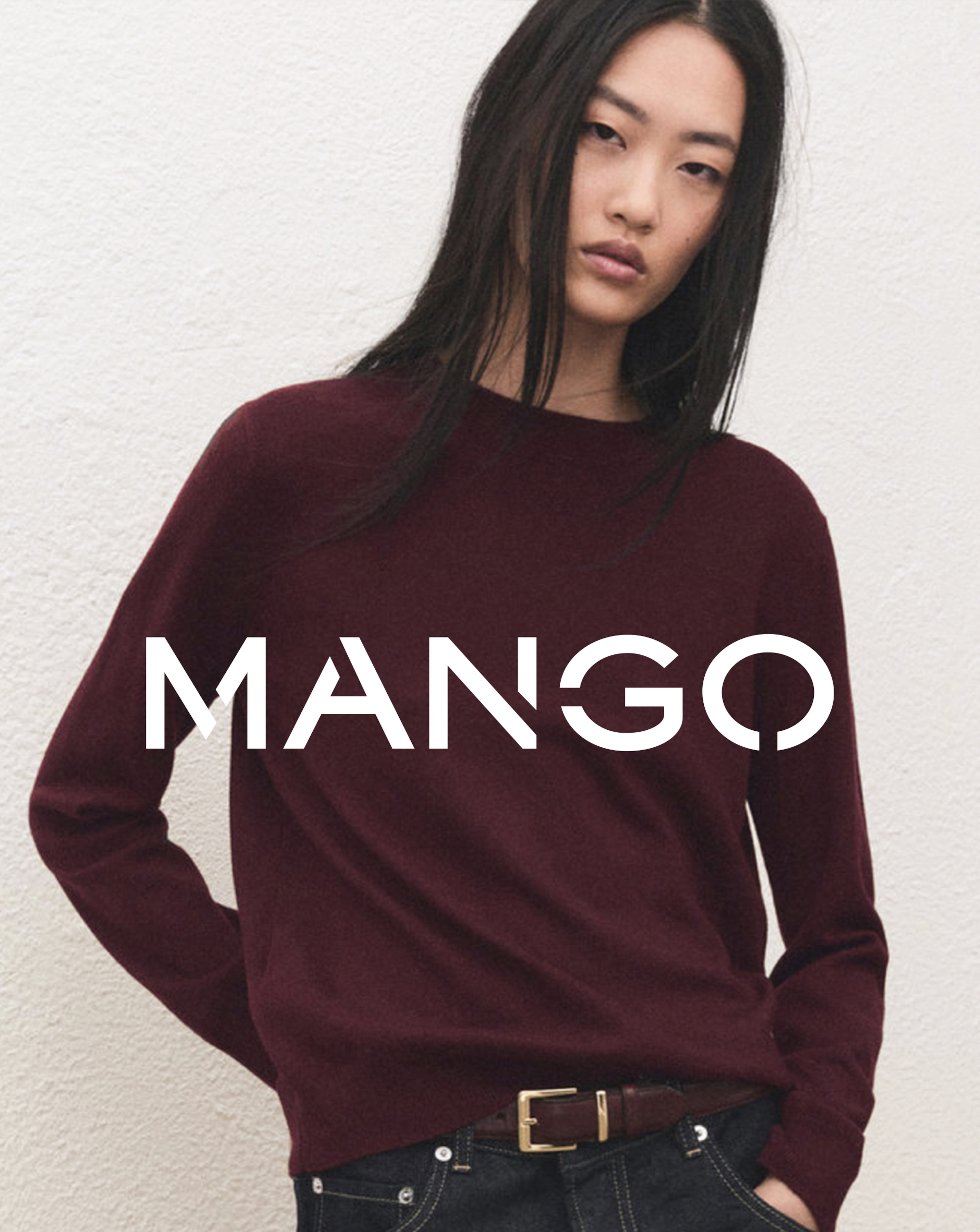 A woman with dark hair wearing a maroon long sleeved Mango top.