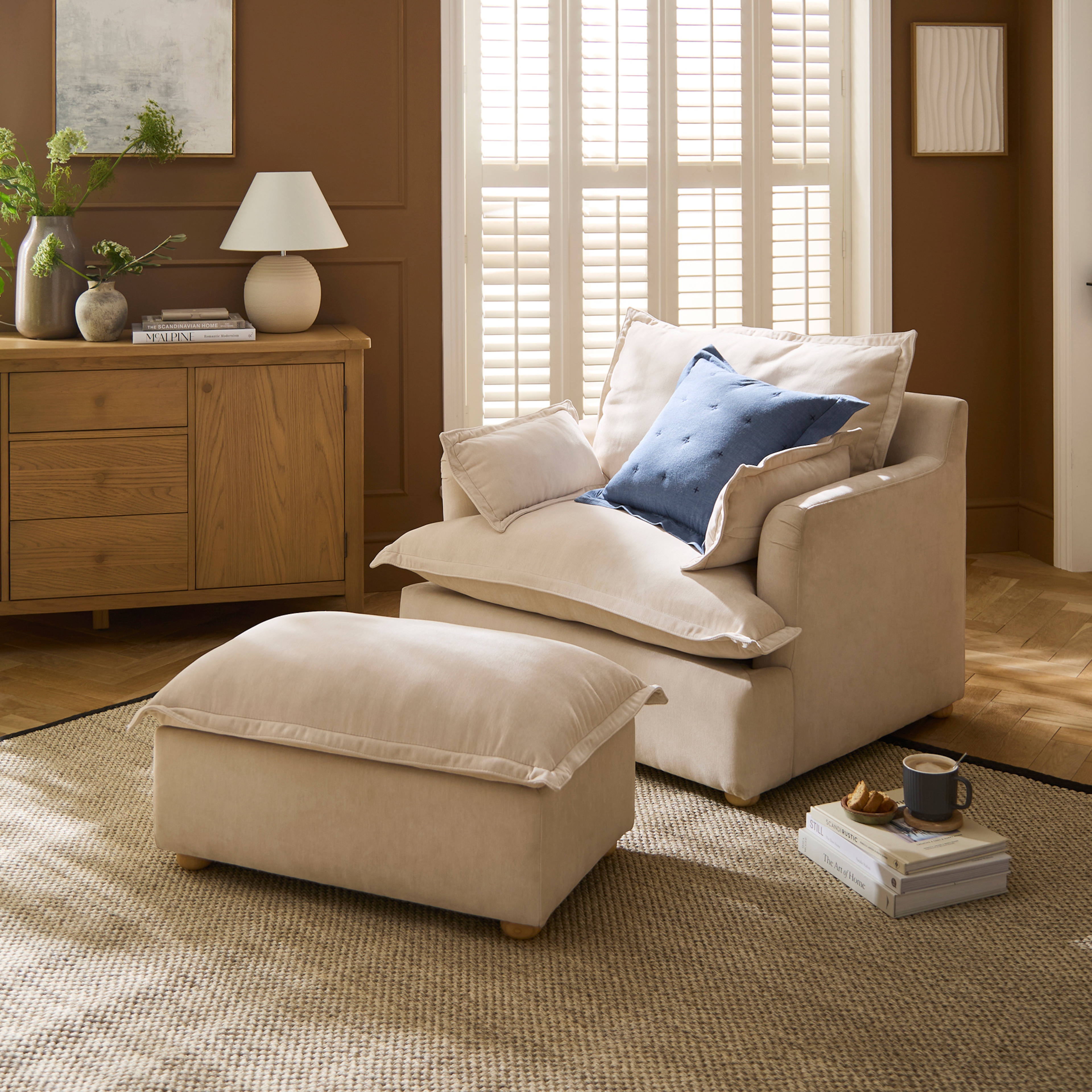 A living room in brown tones with a sofa chair, a table and a rug.