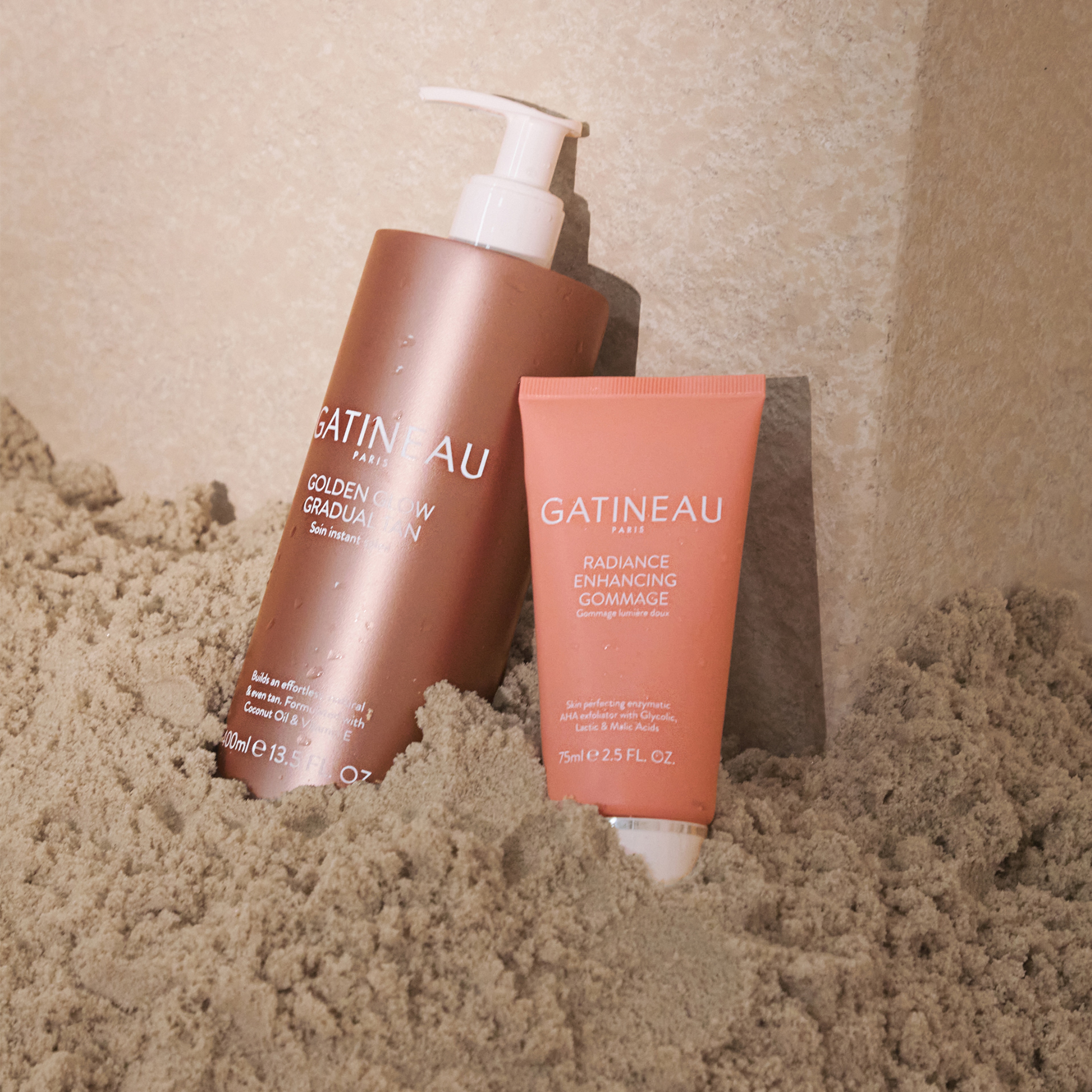 Two Gatineau beauty products sitting in some sand.