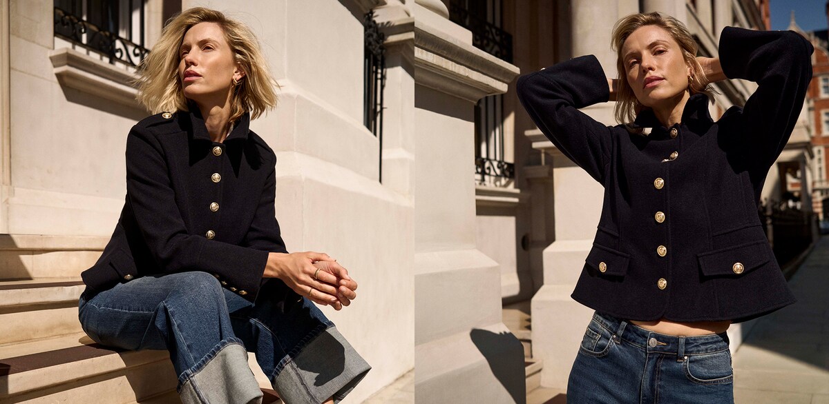A woman in a street wearing a navy coloured short military jacket