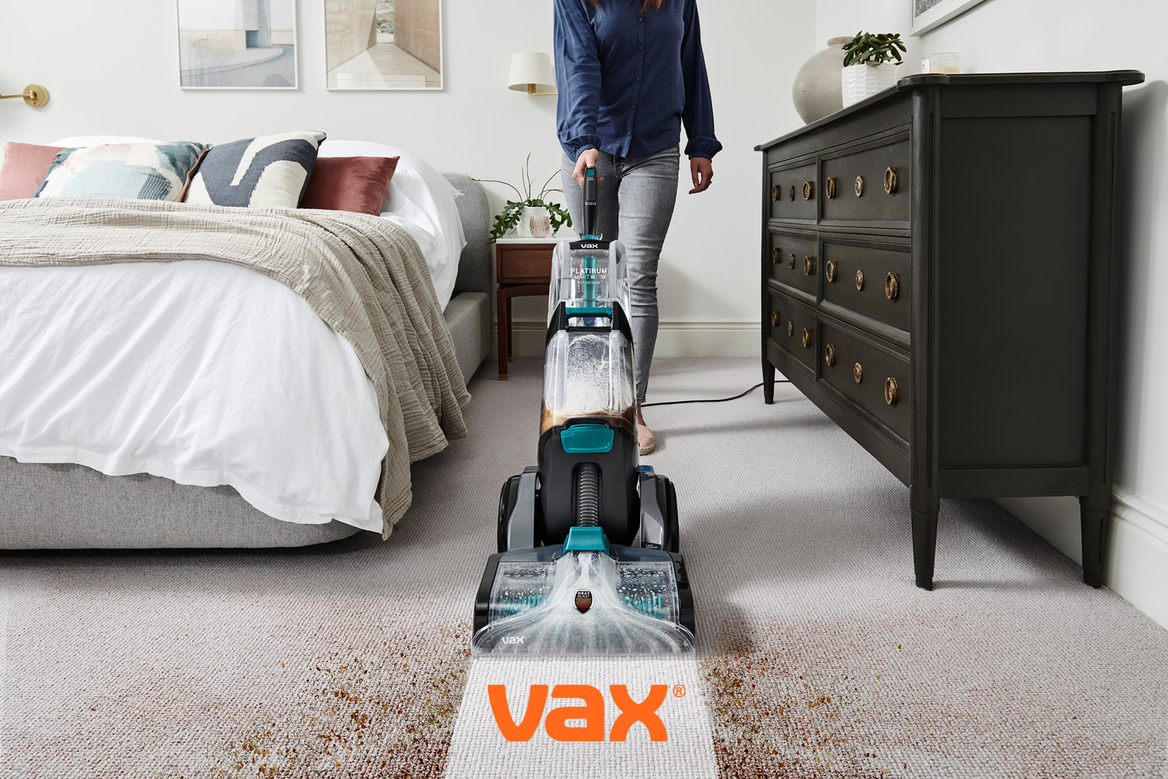 A person cleaning using a Vax upright cleaning appliance