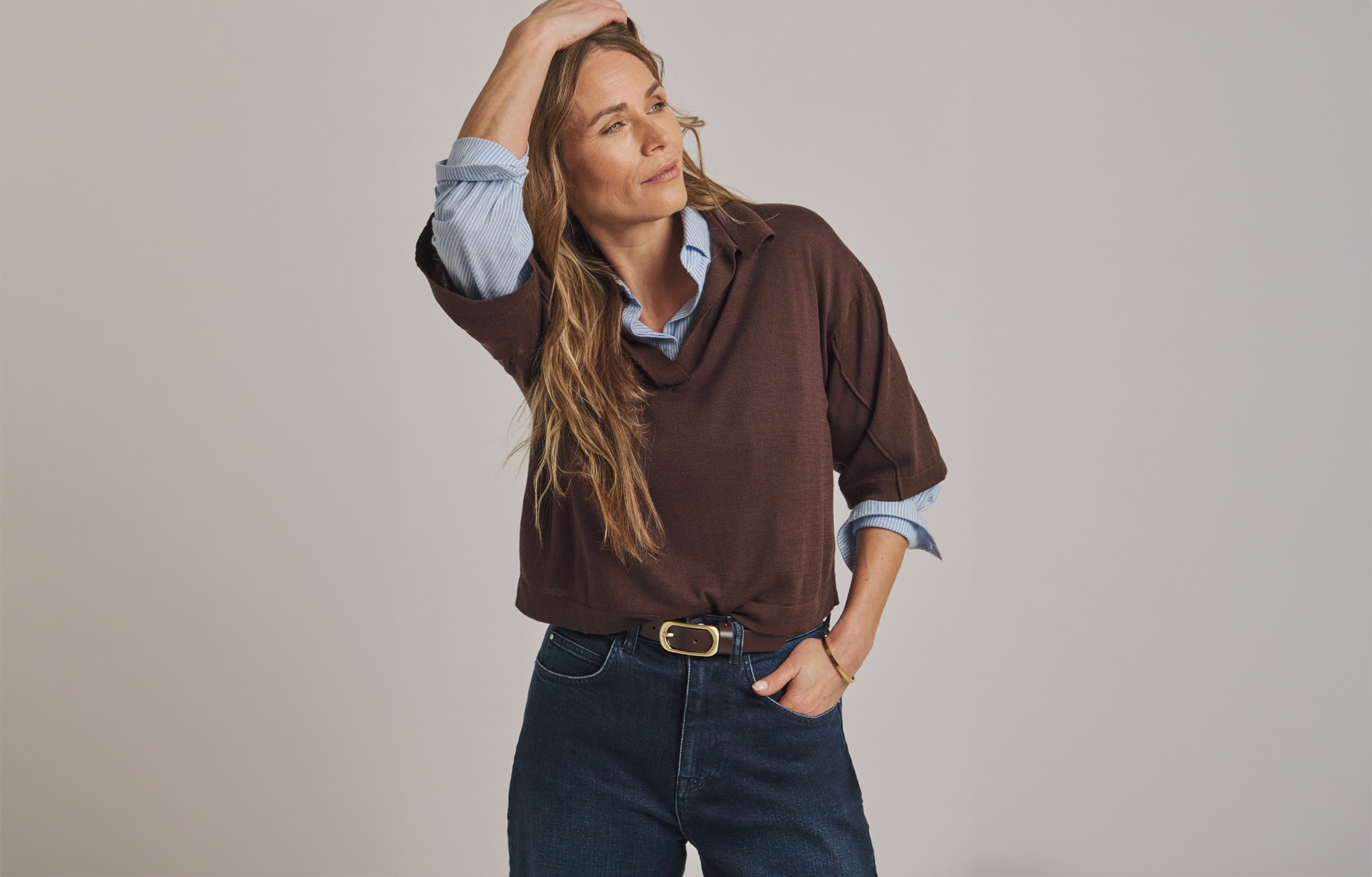 Woman wearing brown jumper and denim jeans