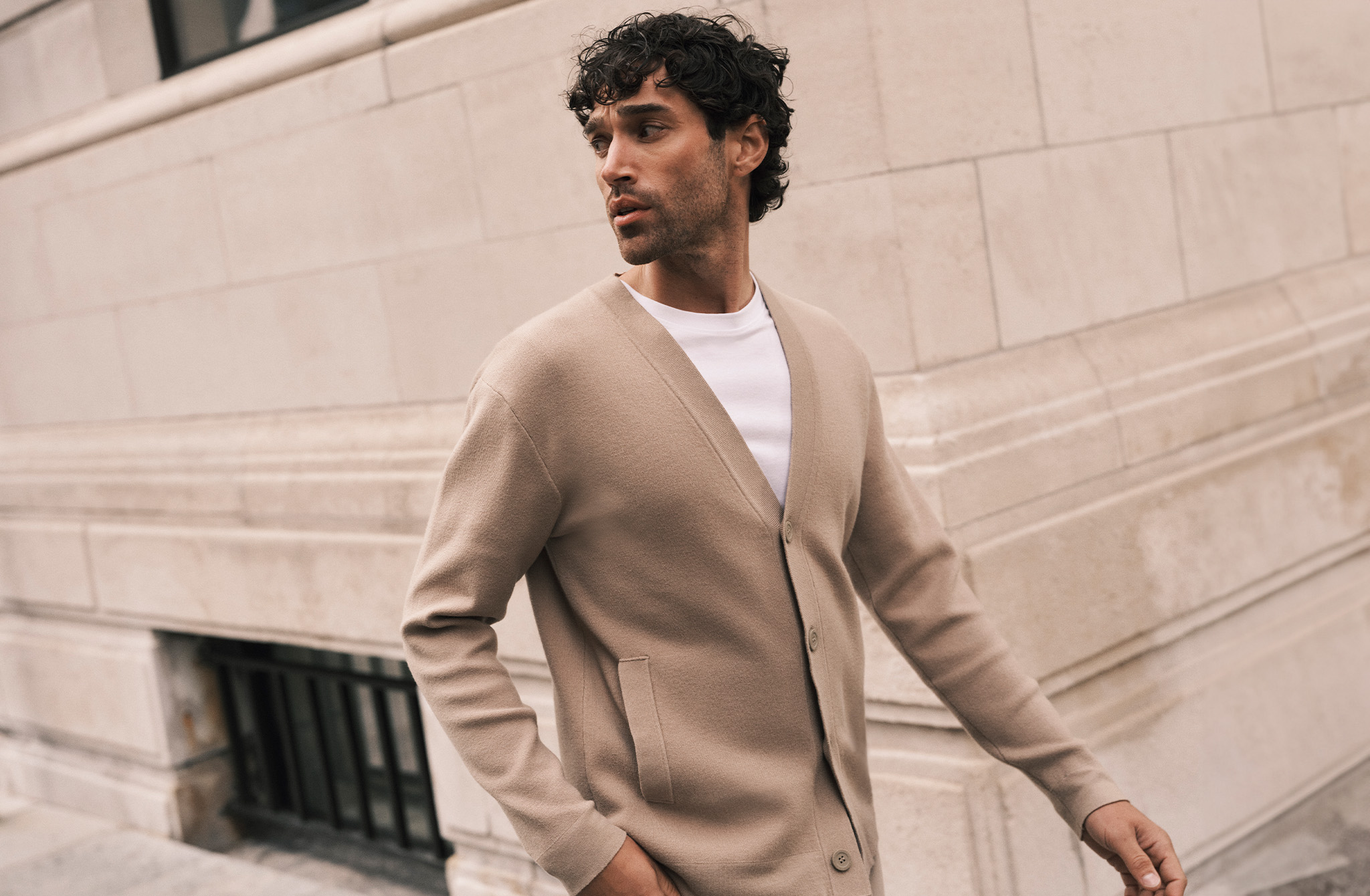 Model wearing a beige Folio cardigan
