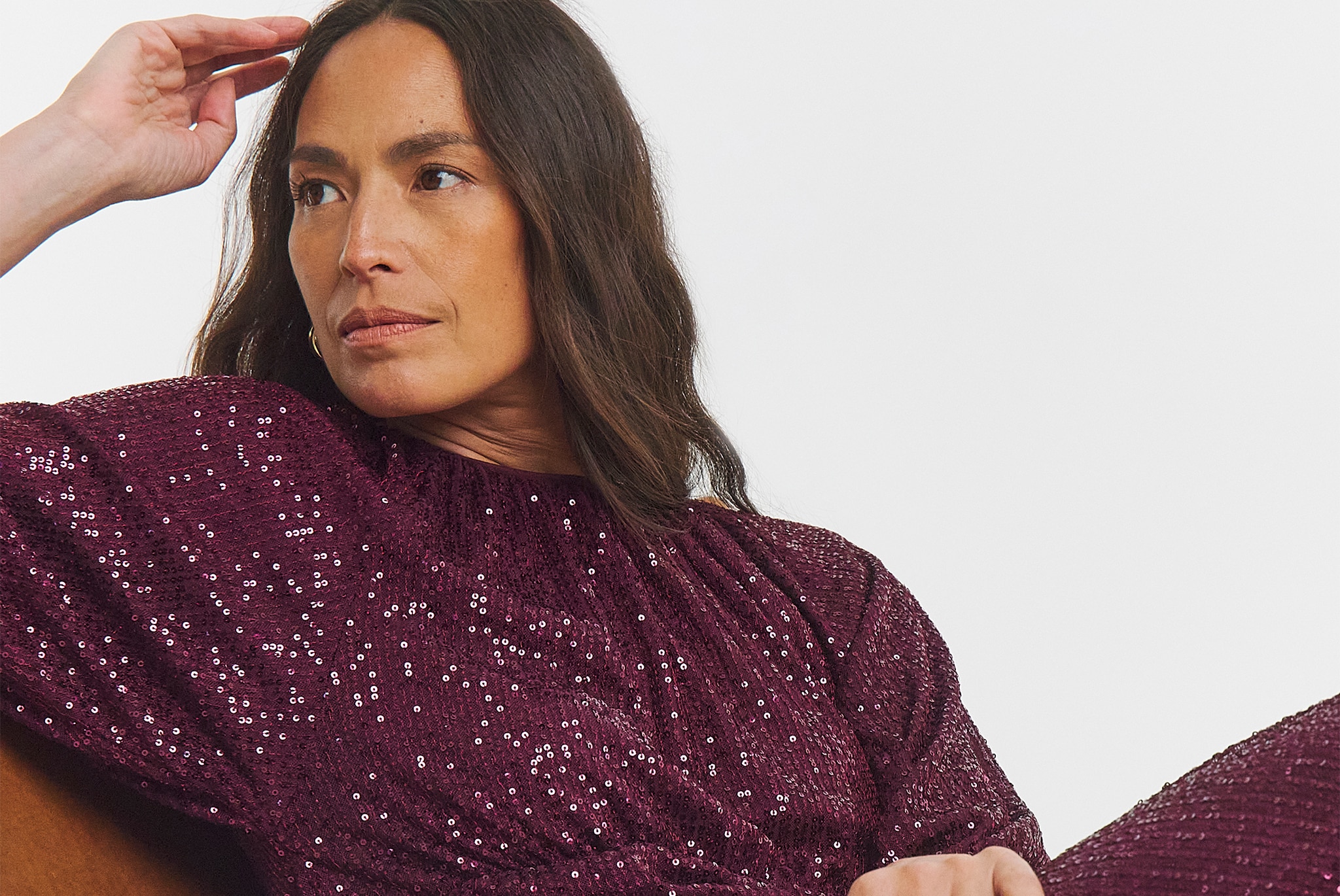 Close-up of a burgundy sequin dress with puff sleeves, highlighting the shimmering fabric and gathered neckline.