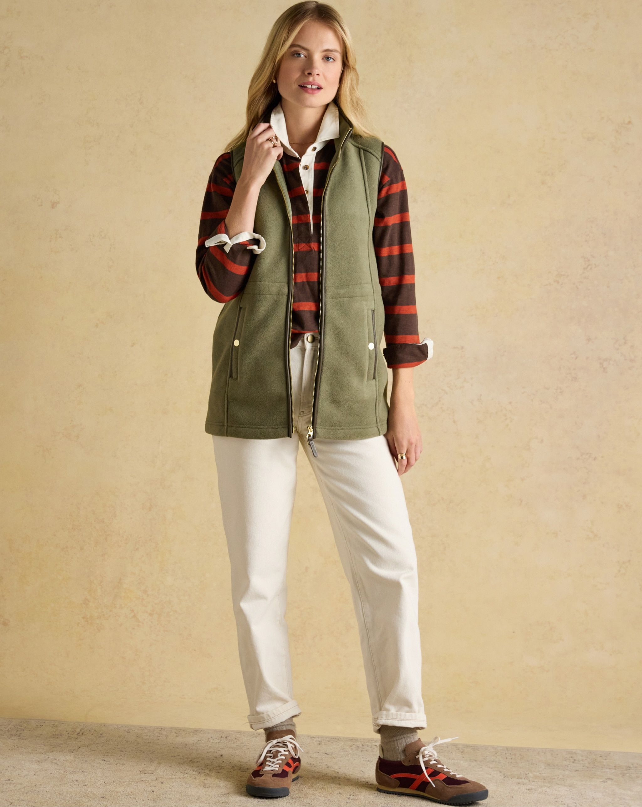 Woman wearing green fleece jacket and white trousers