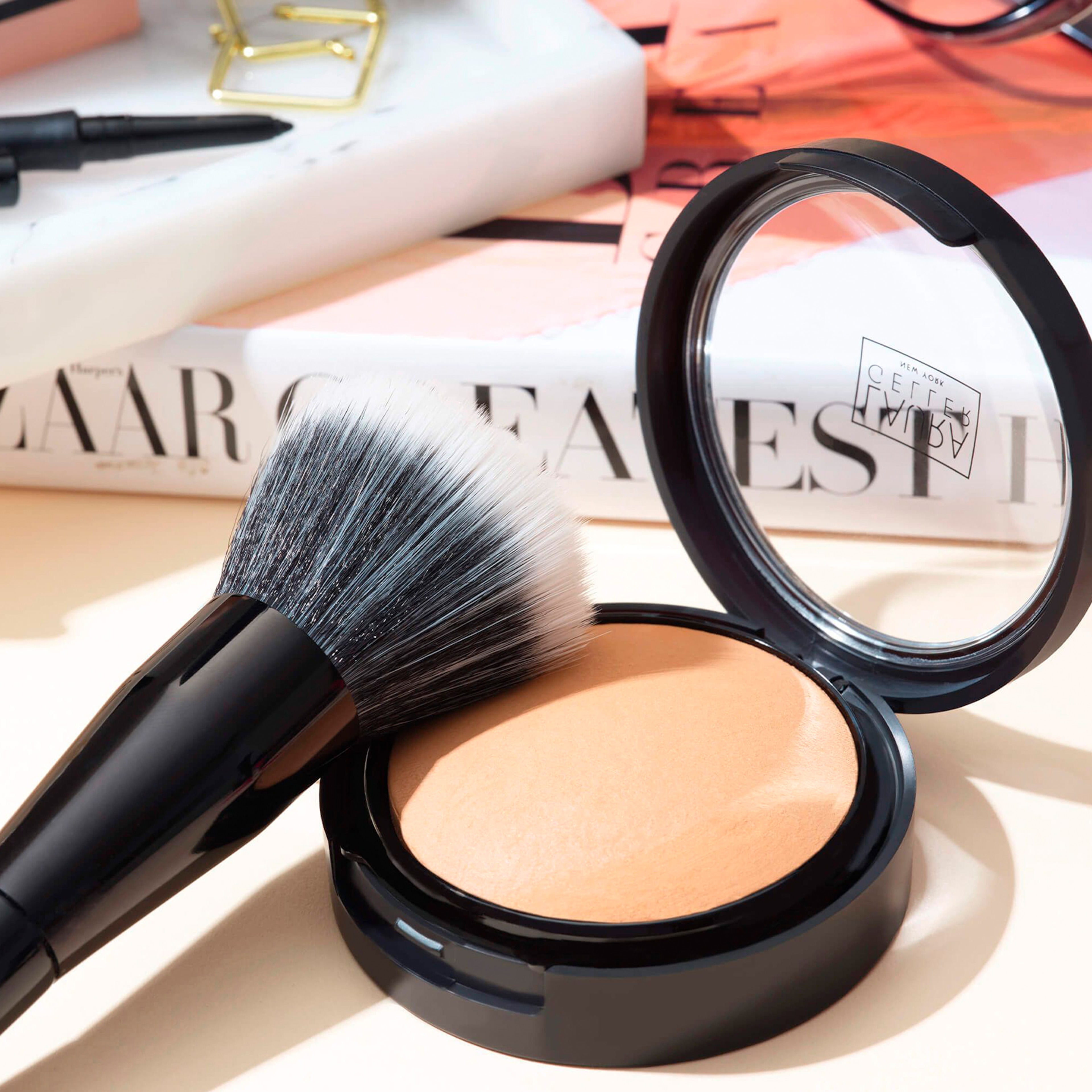 A close up image of some Laura Geller make up and brush