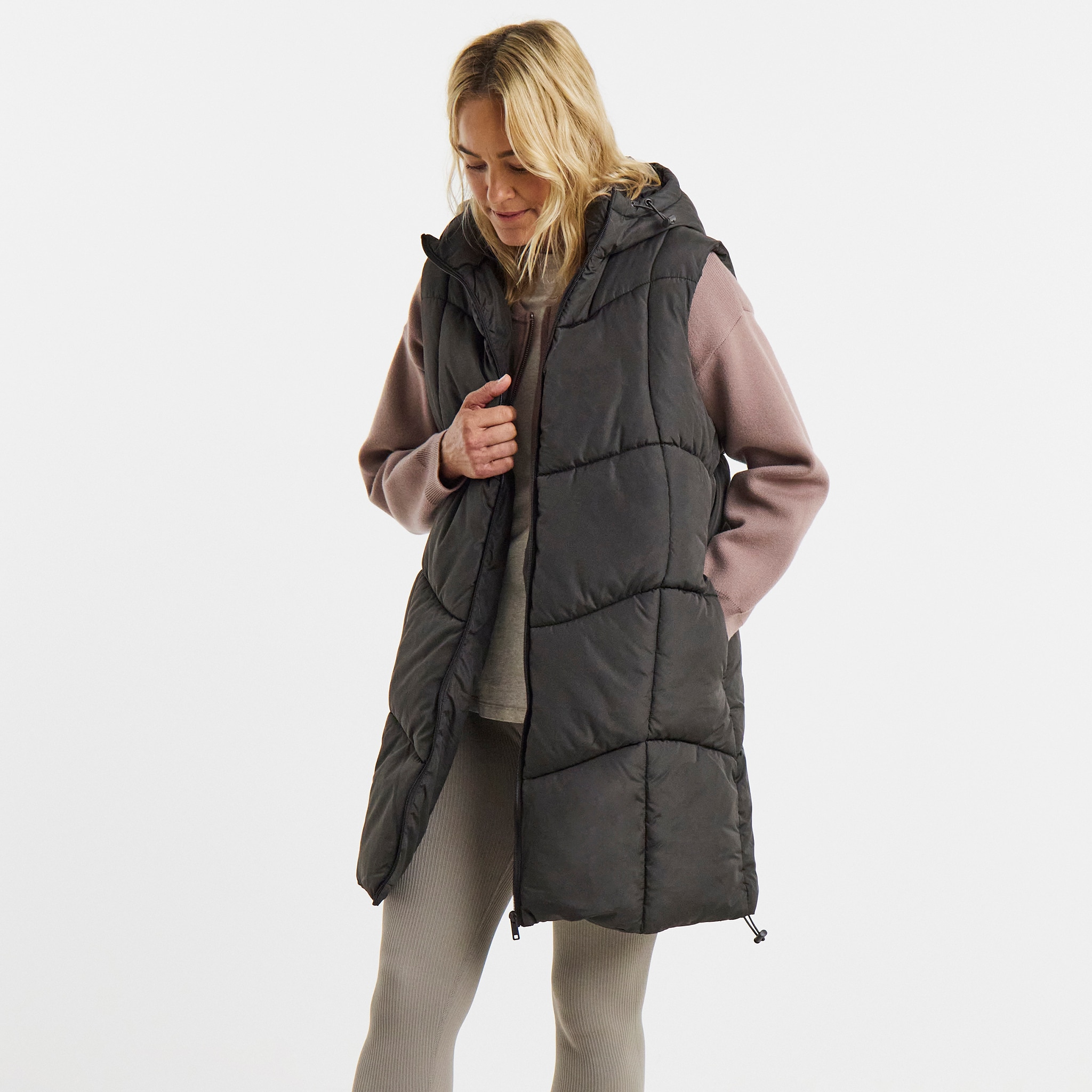 A woman stood wearing a black quilted gilet.