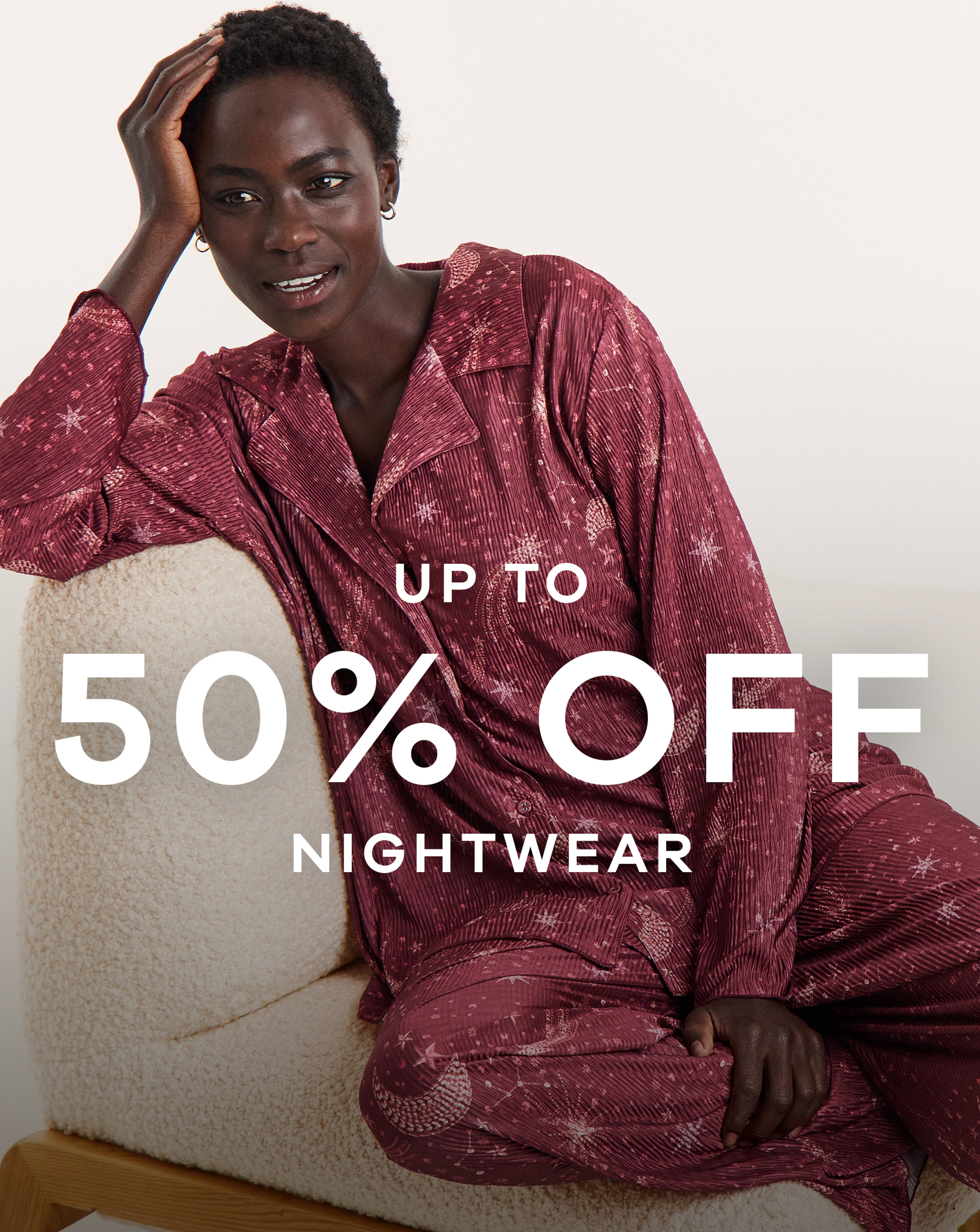 A woman sat on a chair wearing matching red patterned pyjamas