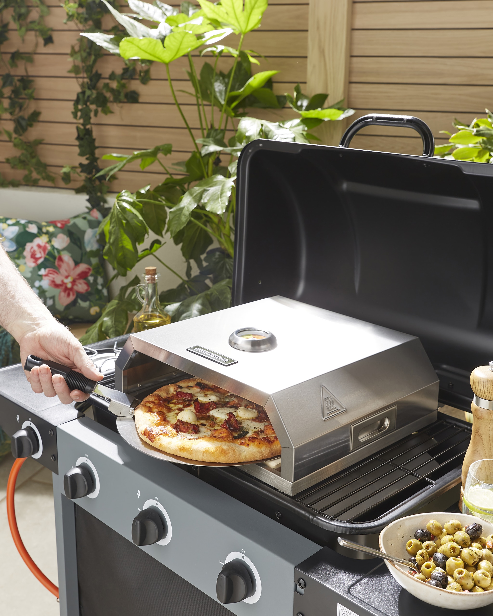 A pizza oven in operation outdoors in a garden.