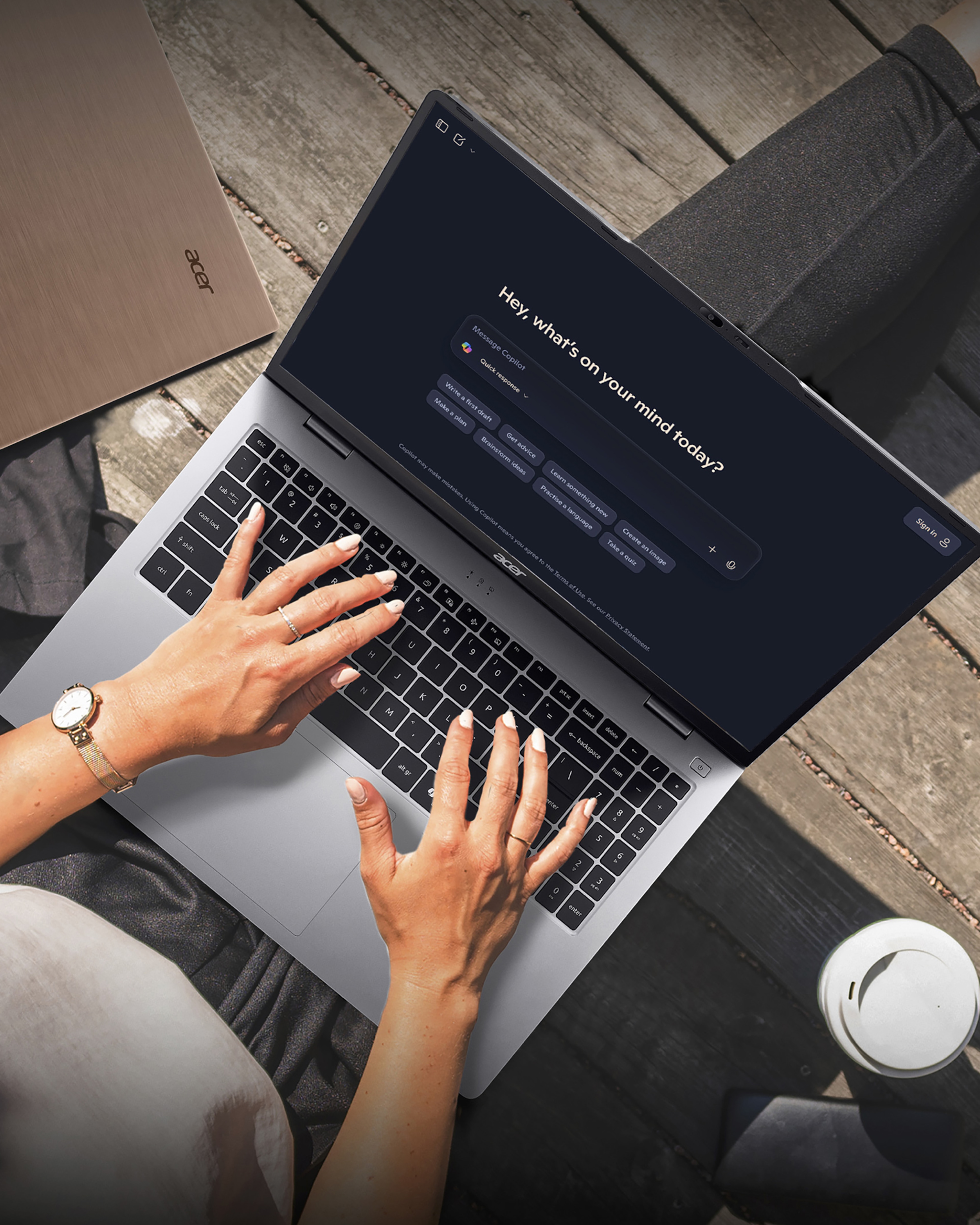 A person sat down using a laptop on their lap.