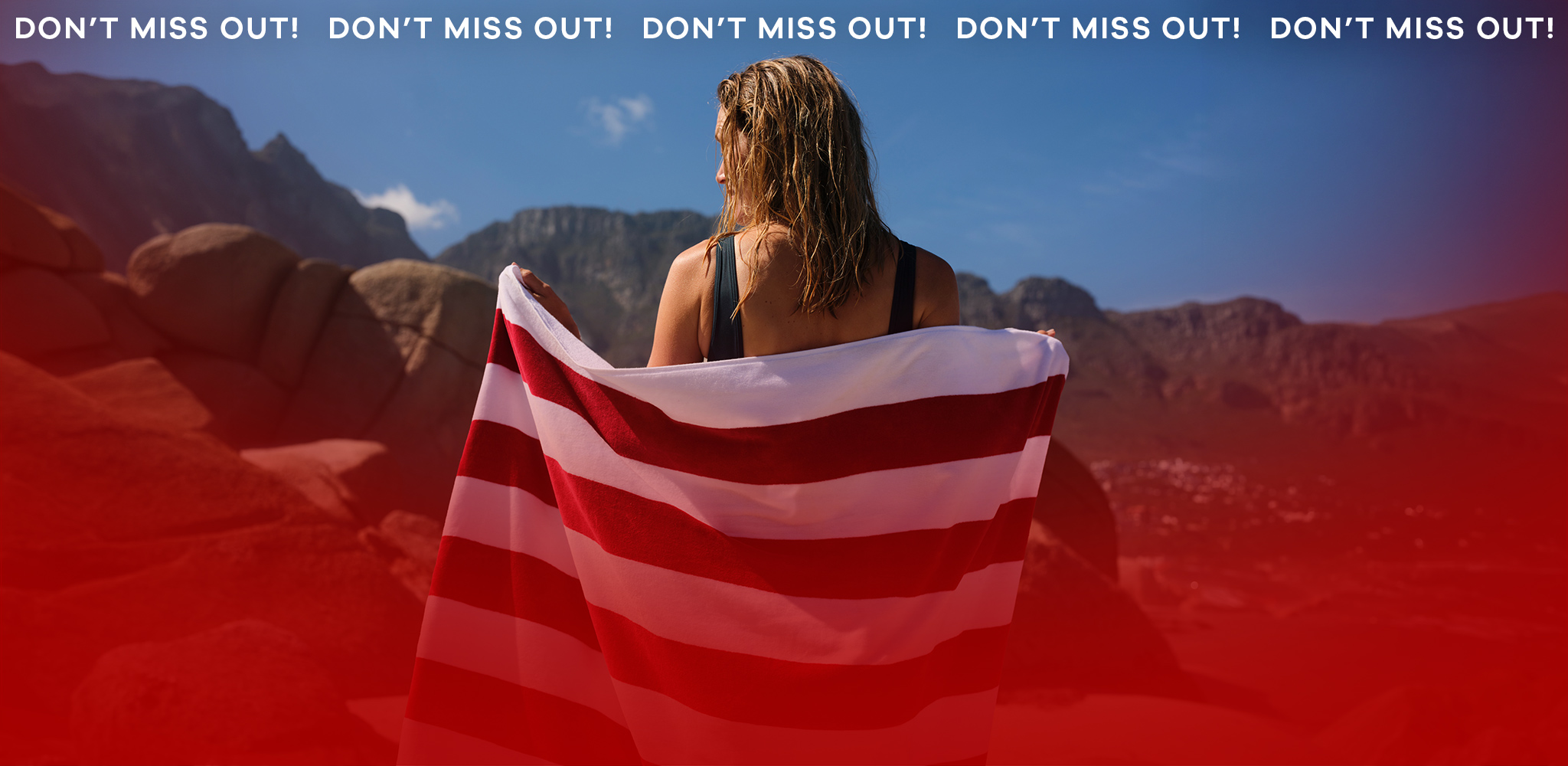 A lady looking away with red and white striped towel draped over her shoulders.