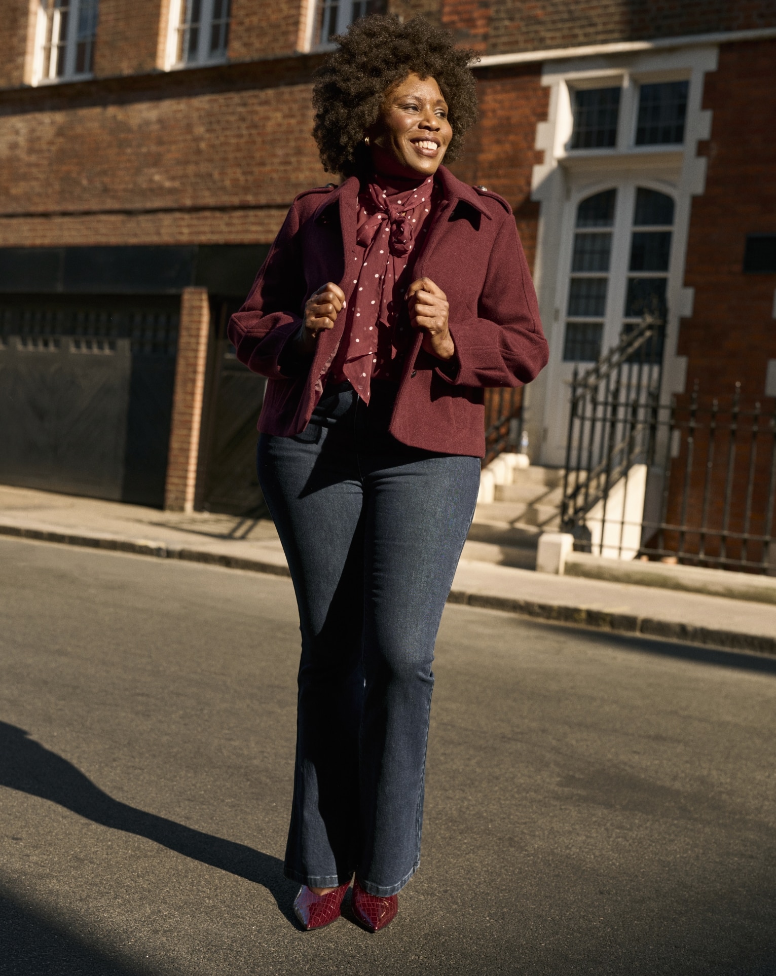 Woman wearing burgundy short button front jacket