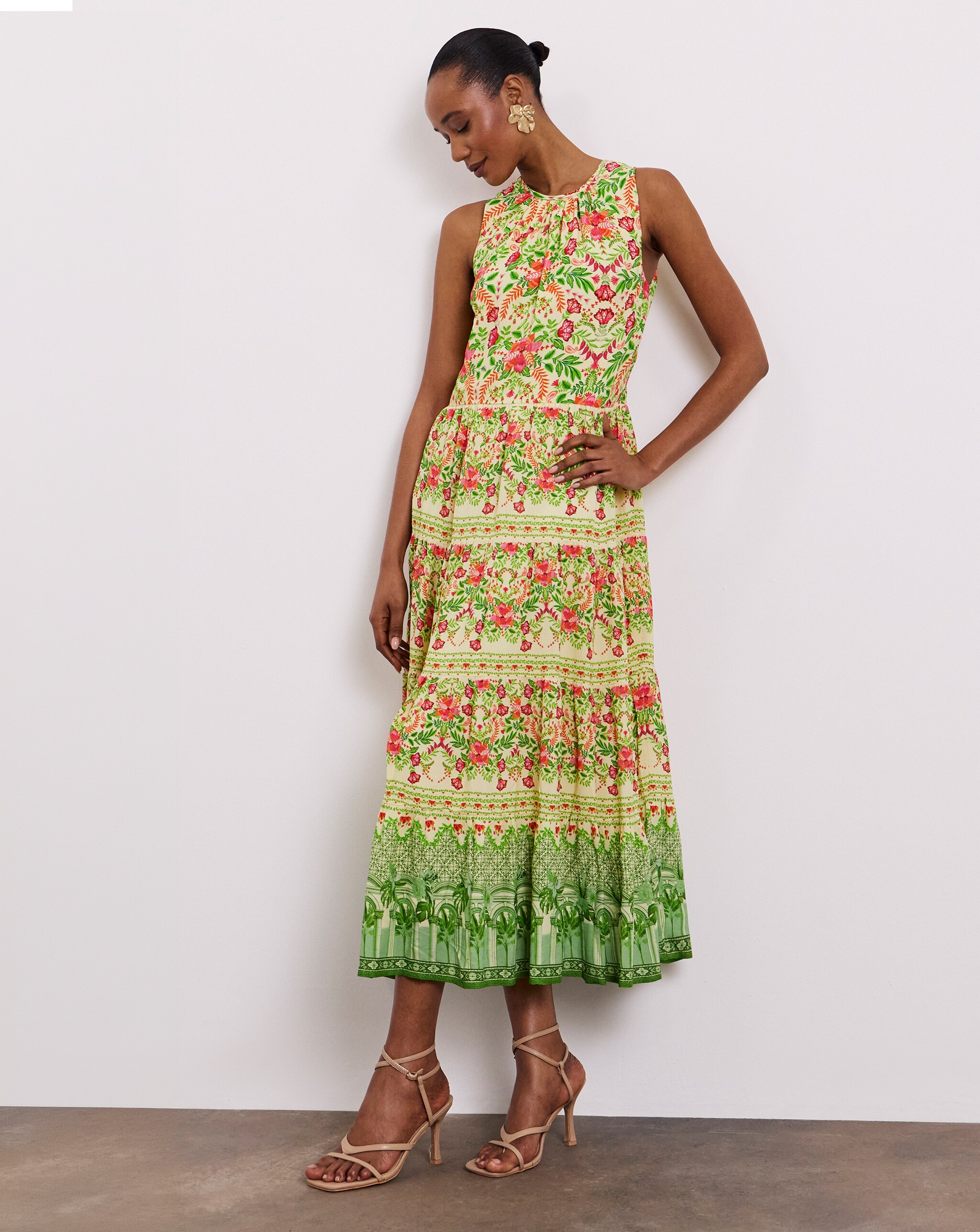 Person wearing a Joanna Hope sleeveless floral midi dress with tiered detailing and nude strappy heels.