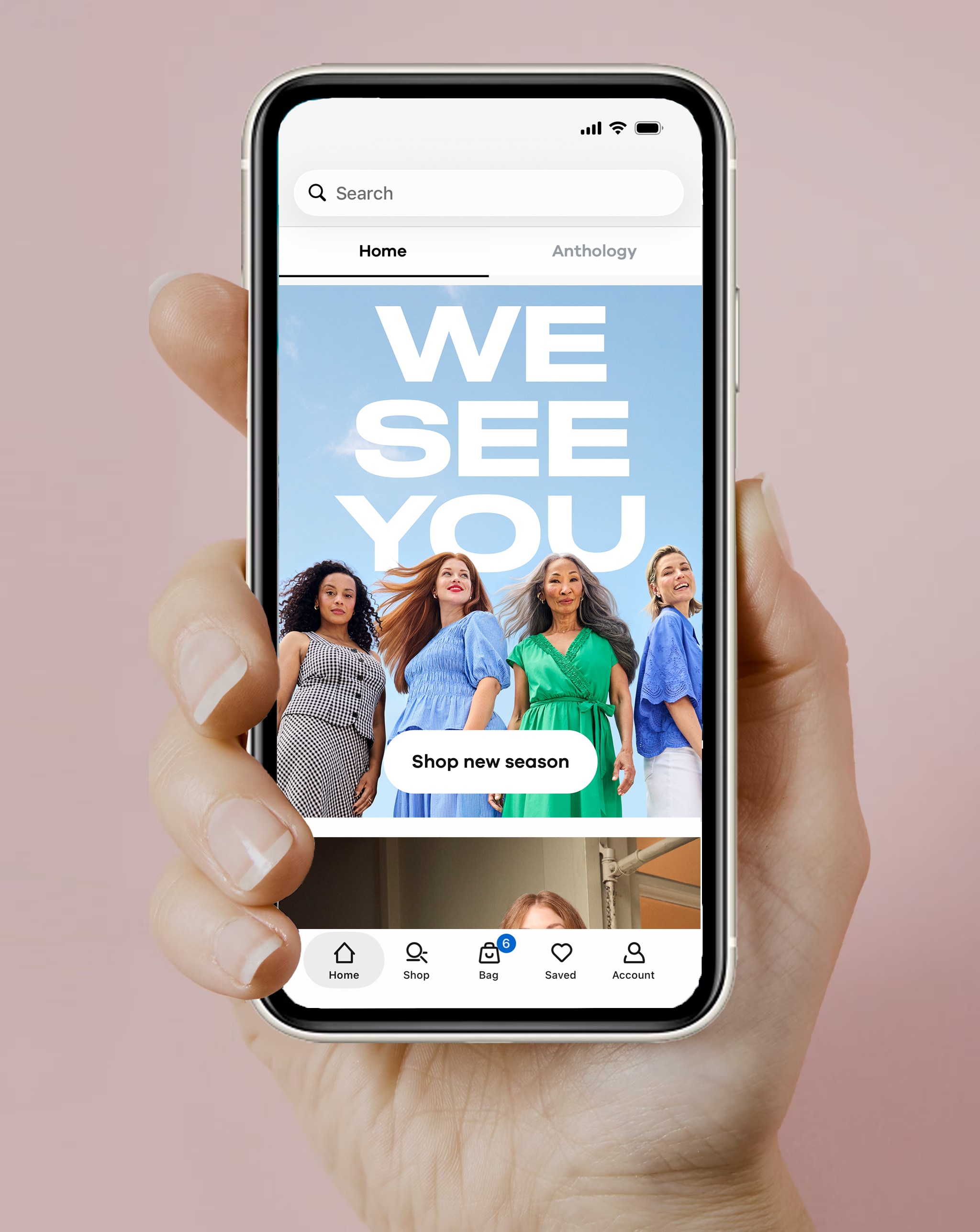 A person holding mobile phone, displaying the JD Williams app home screen.