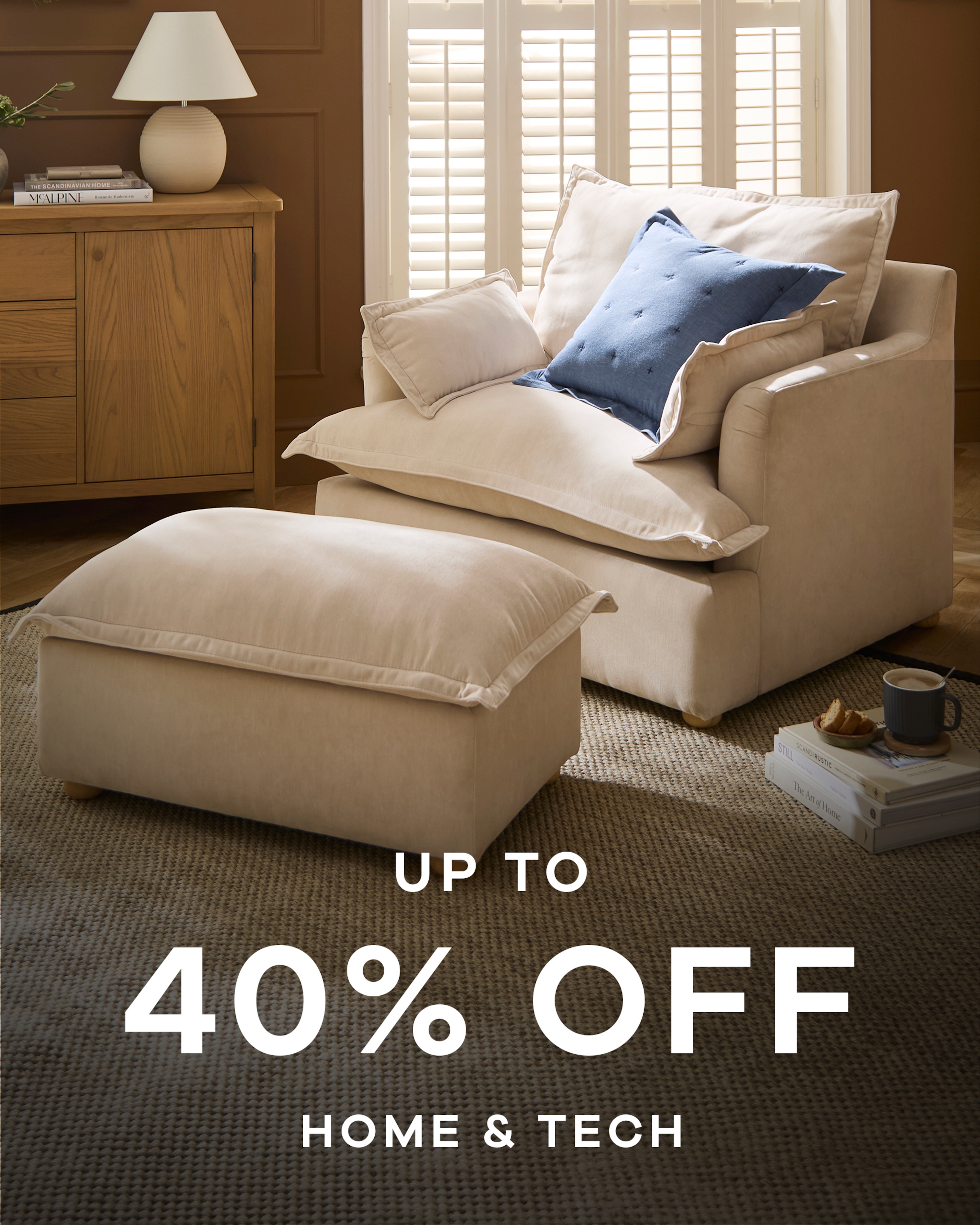 A cream coloured sofa chair with matching footrest in a living room. Up to 40% off home & tech.