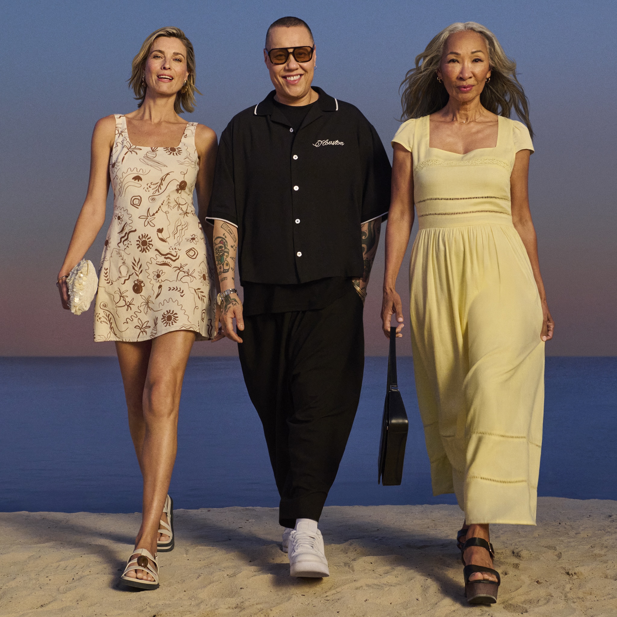 Gok Wan with a lady either side of him walking forwards.