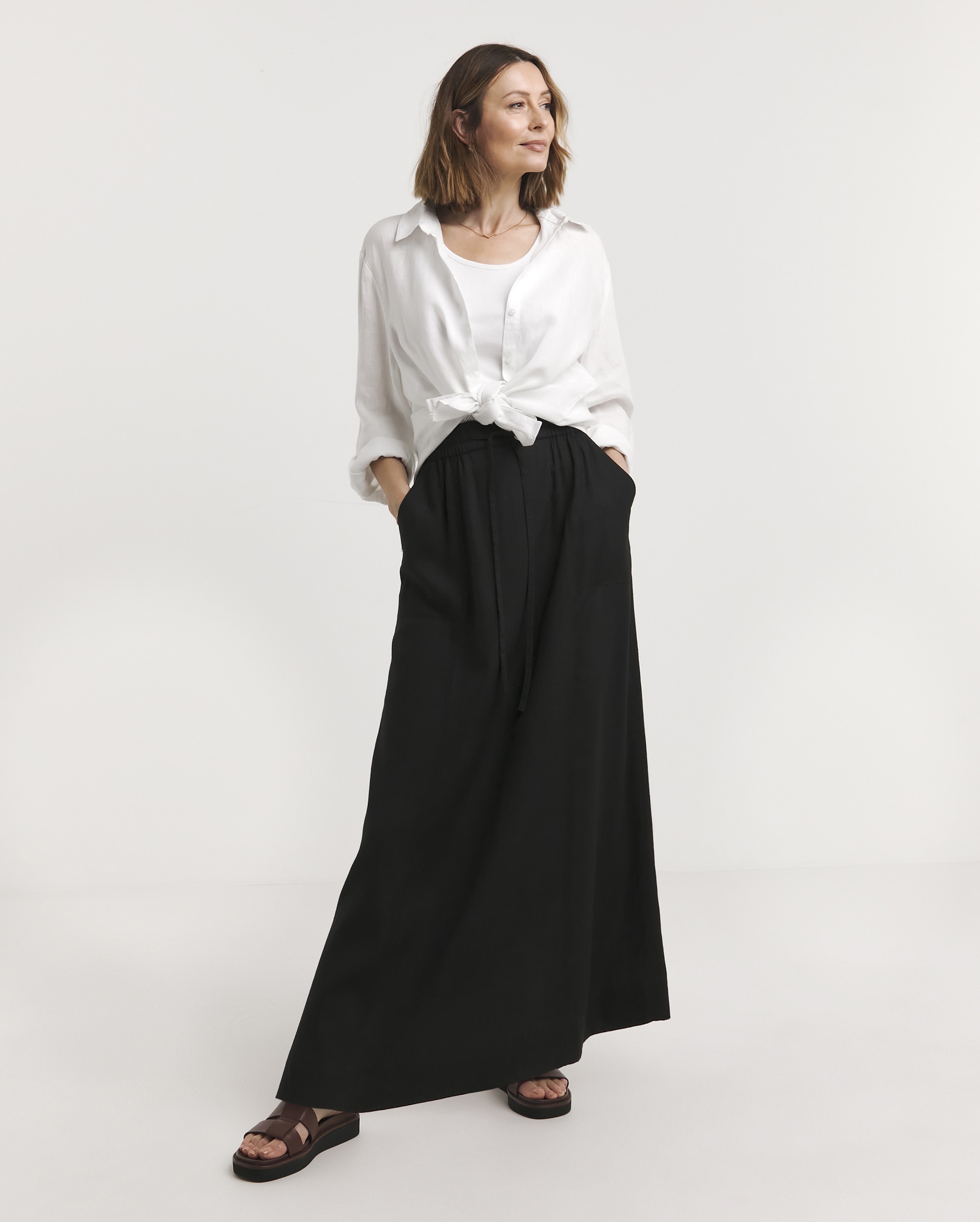 A lady wearing a white blouse with a black maxi dress