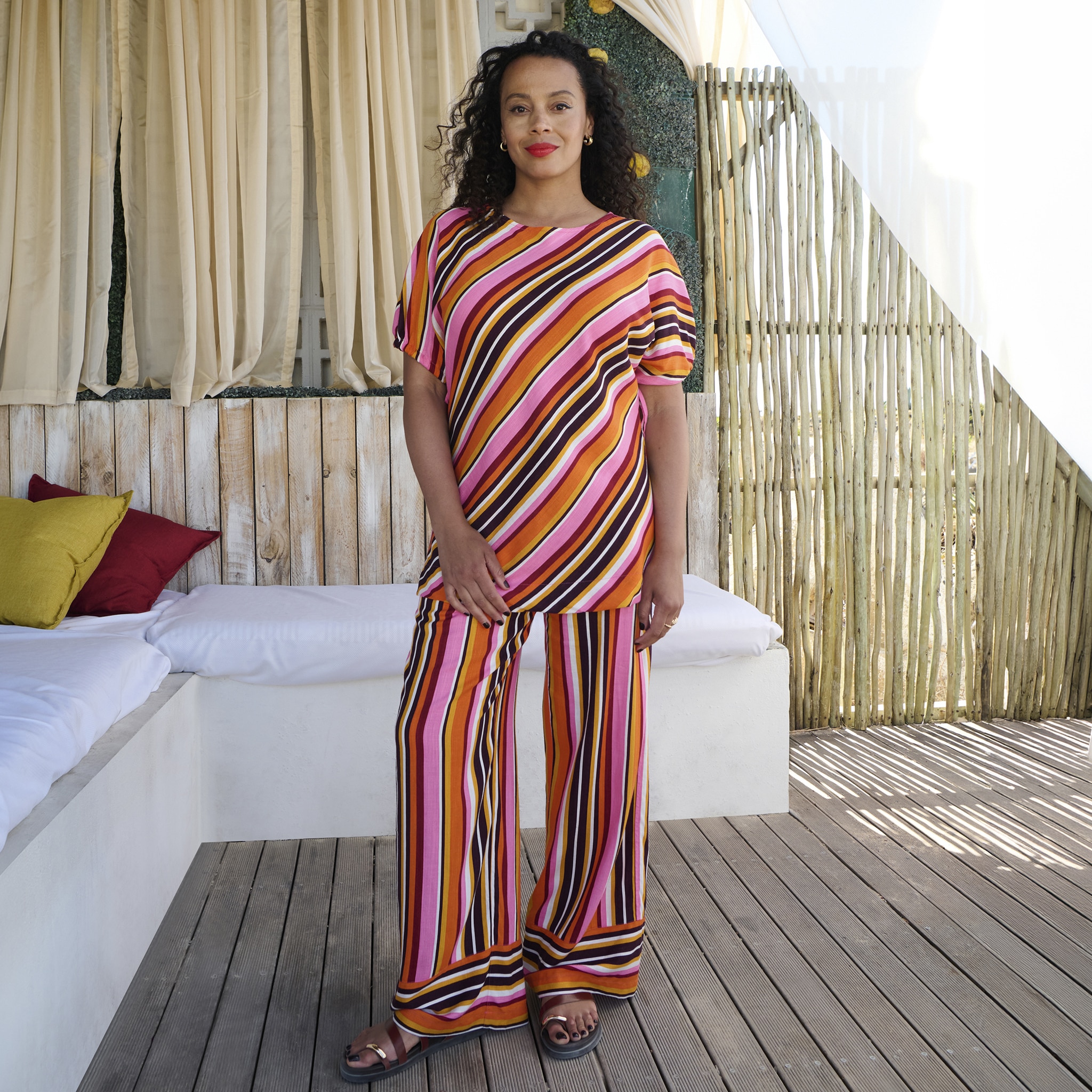A lady wearing a matching two piece stiped outfit.