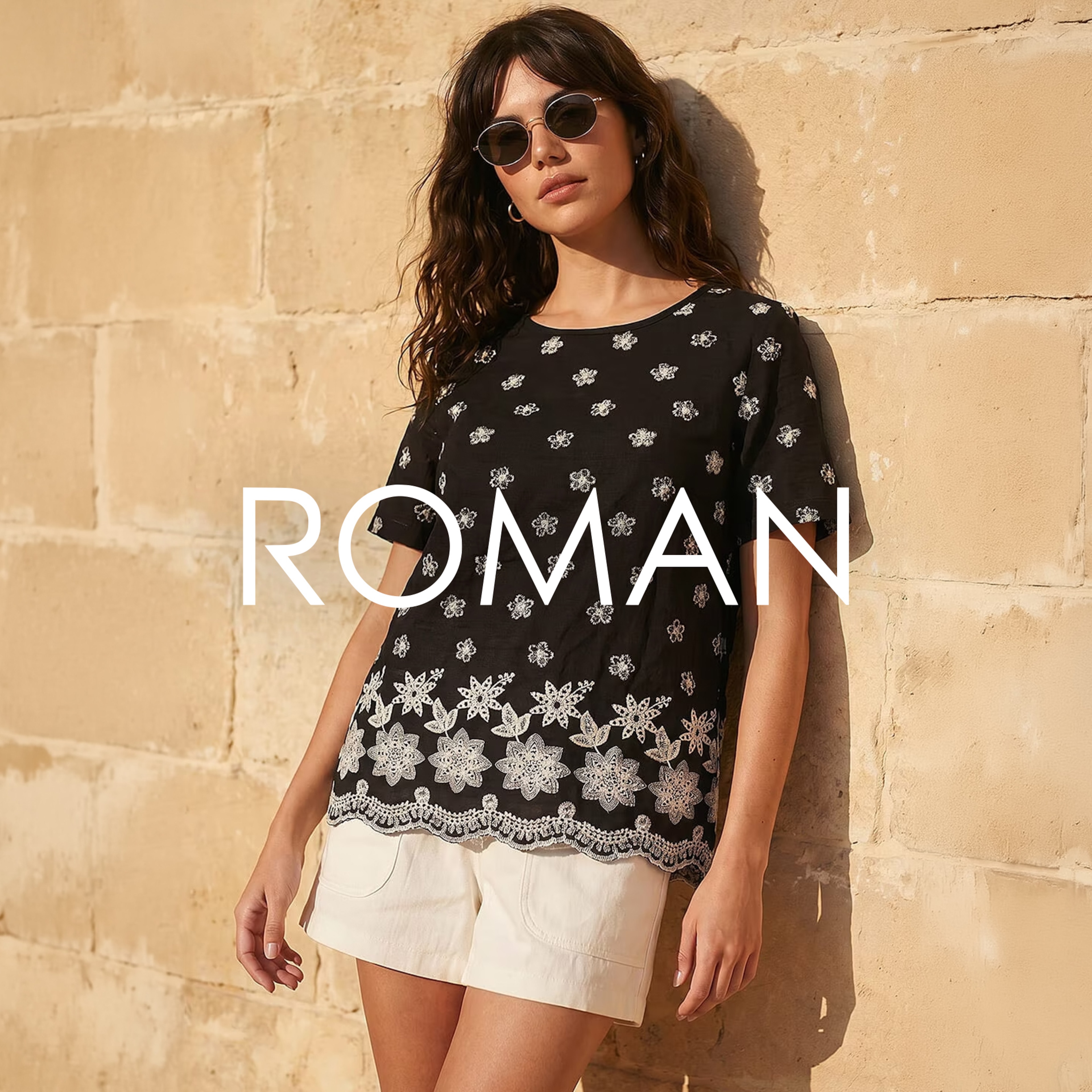 A woman leant against a wall wearing a ROMAN top.