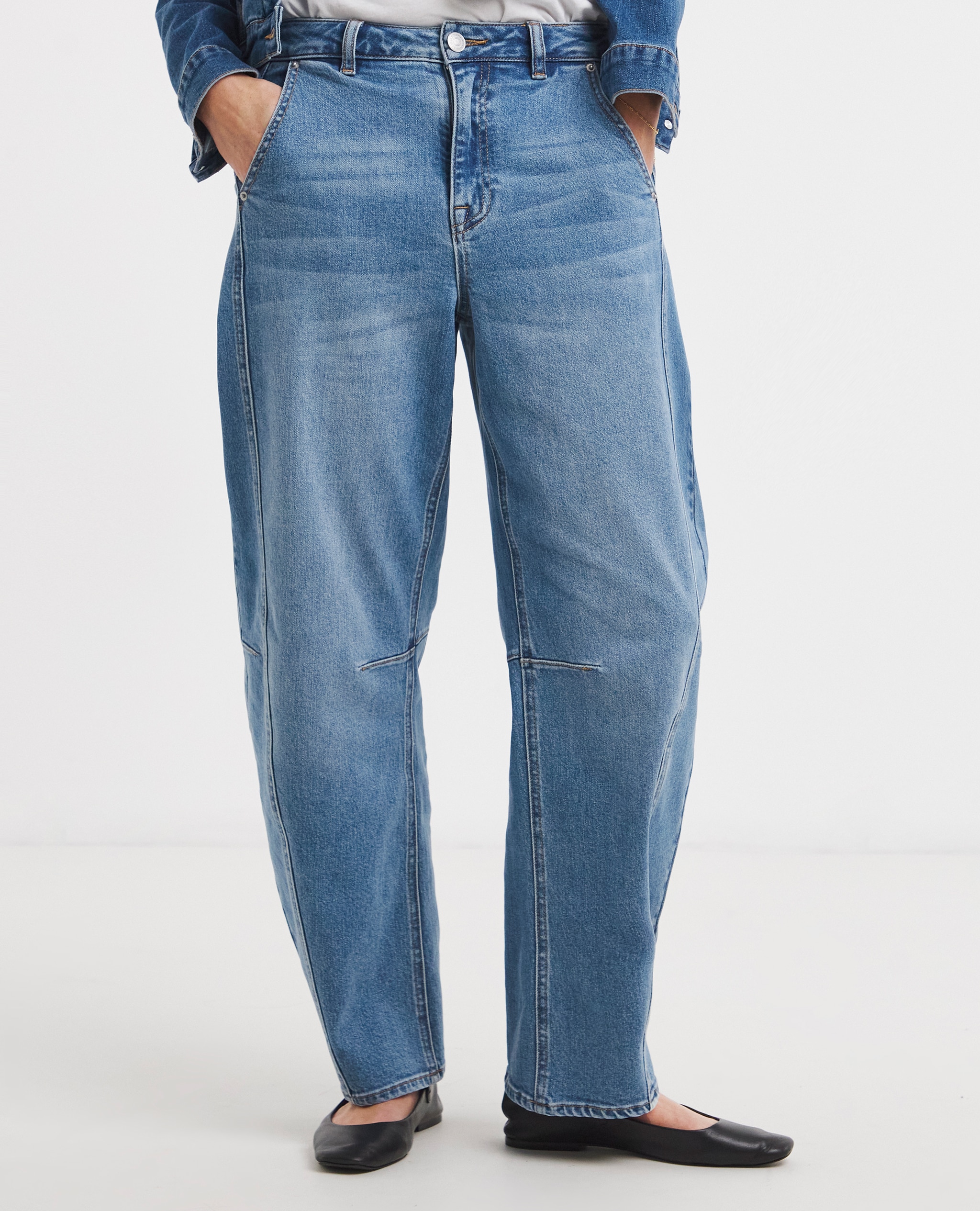 Barrel. Model wears Blue Authentic Stretch Tapered Jeans