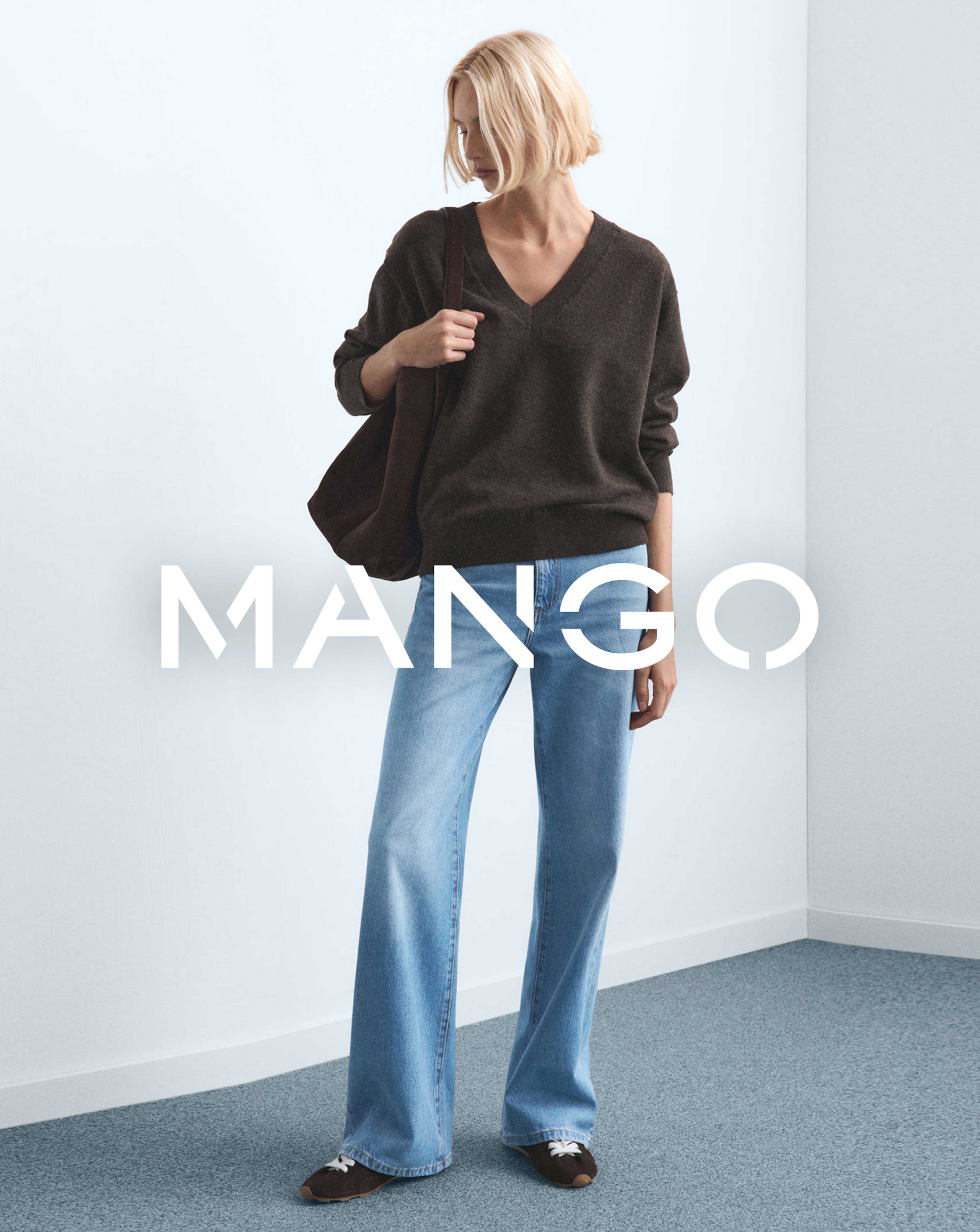 Woman wearing brown jumper and denim jeans by Mango