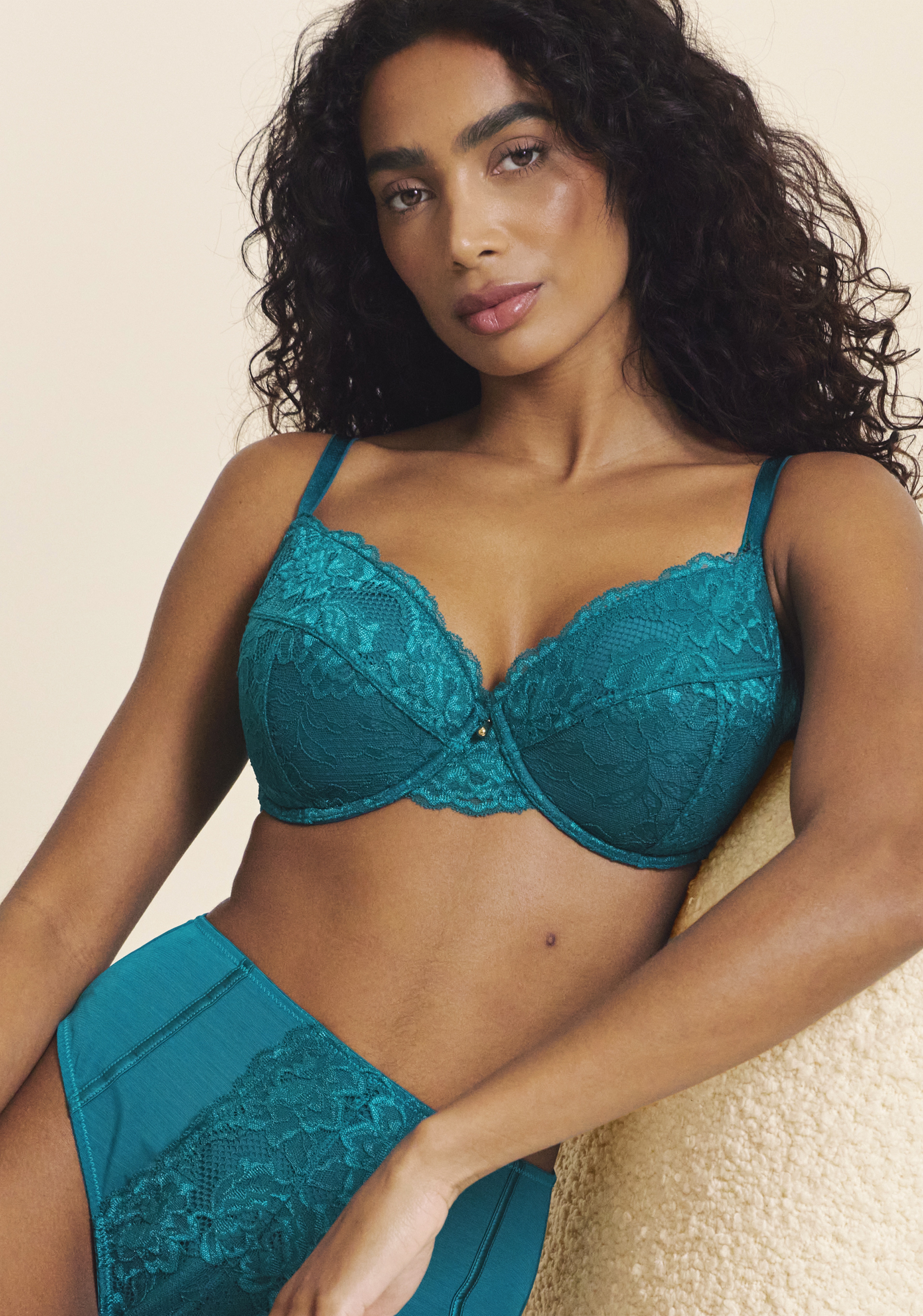 A woman sat wearing matching teal coloured lingerie.