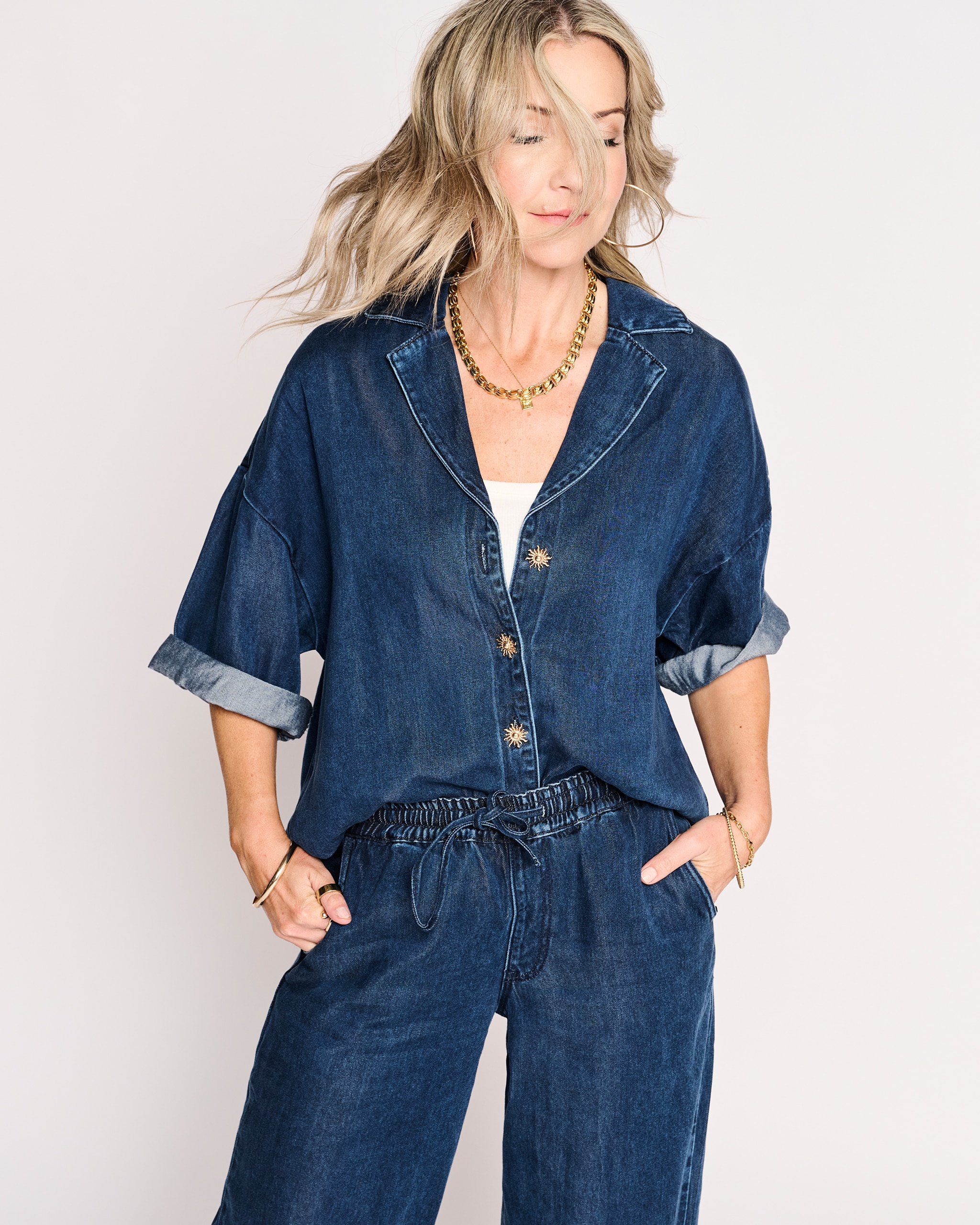Model is wearing a blue Tencel™ denim short sleeve shirt with a pair of blue Lyocell denim balloon leg jogger jeans.