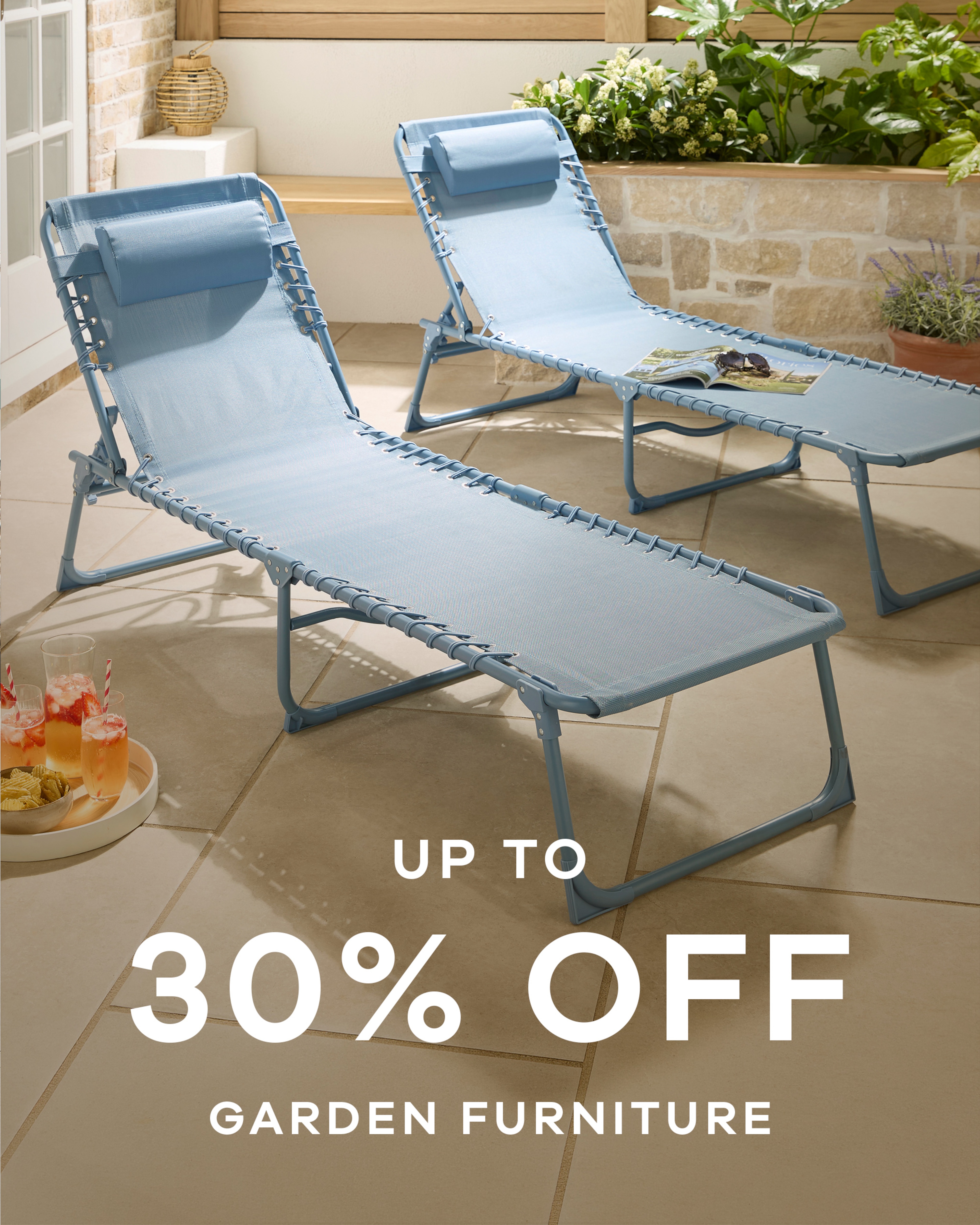 2 sun loungers in a back garden. Up to 30% off garden furniture
