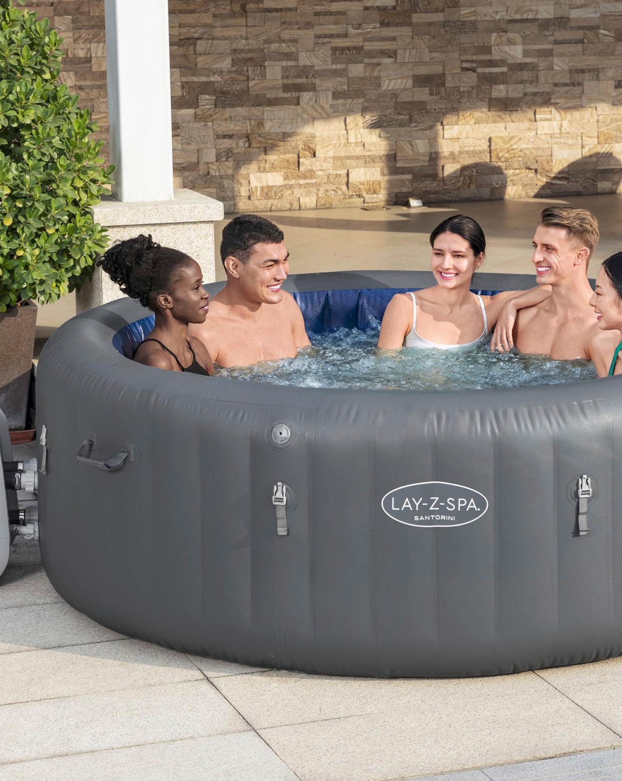 Four people enjoying a Lay Z Spa in the garden