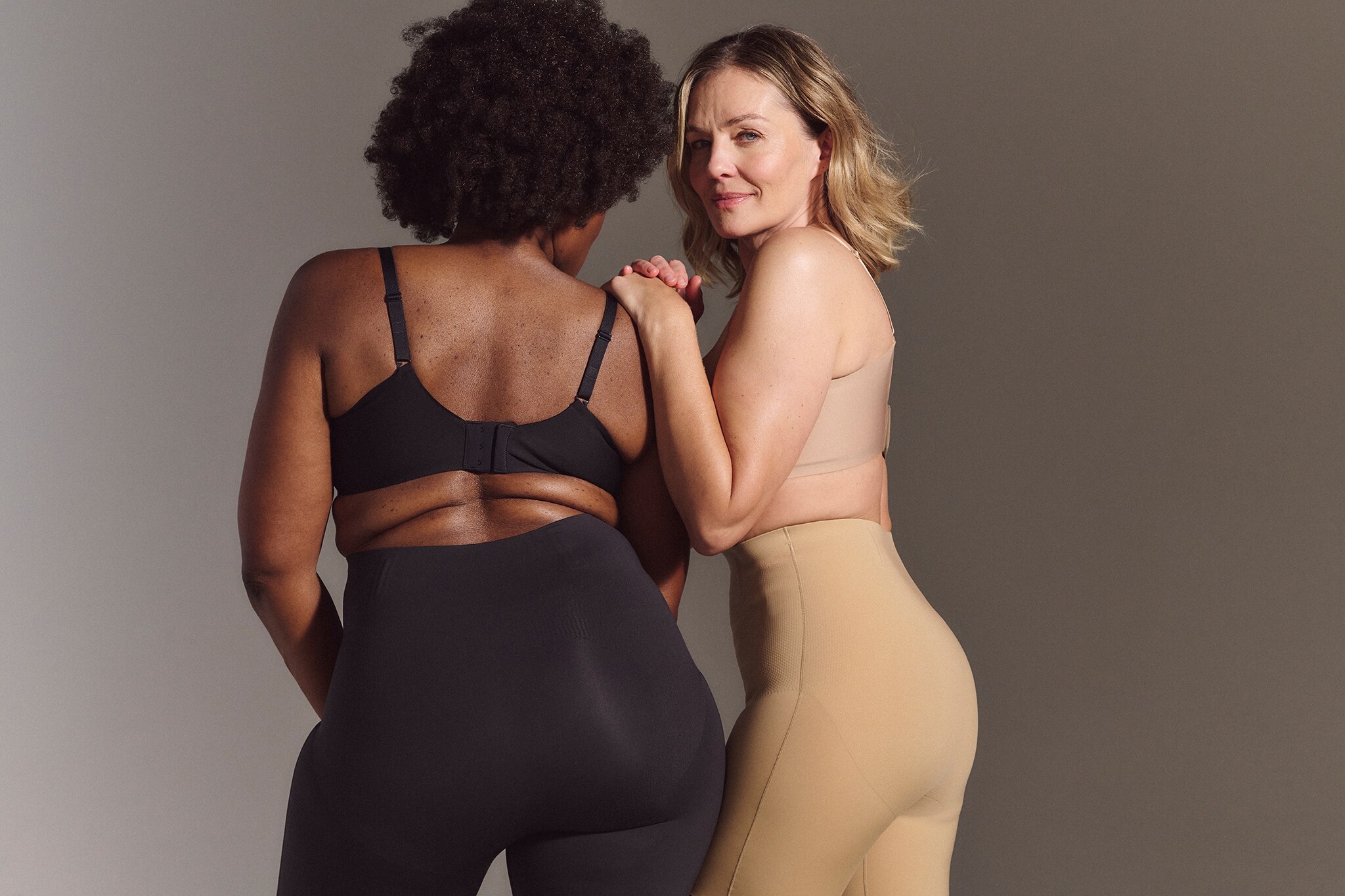 Two ladies wearing shapewear. One wearing lack and the other wearing blush colour.