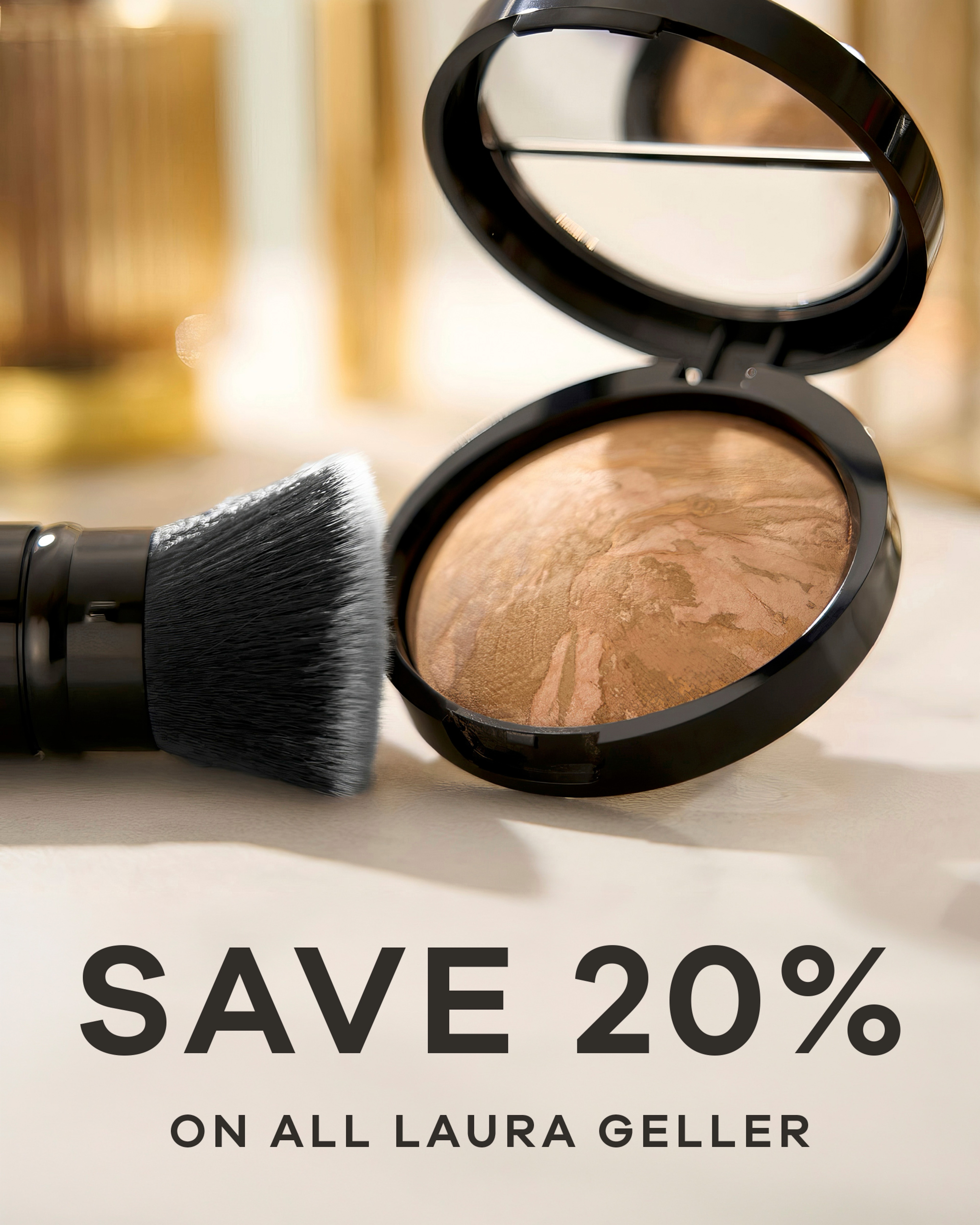 Make up and a brush on a table top. Save 20% on all Laura Geller.