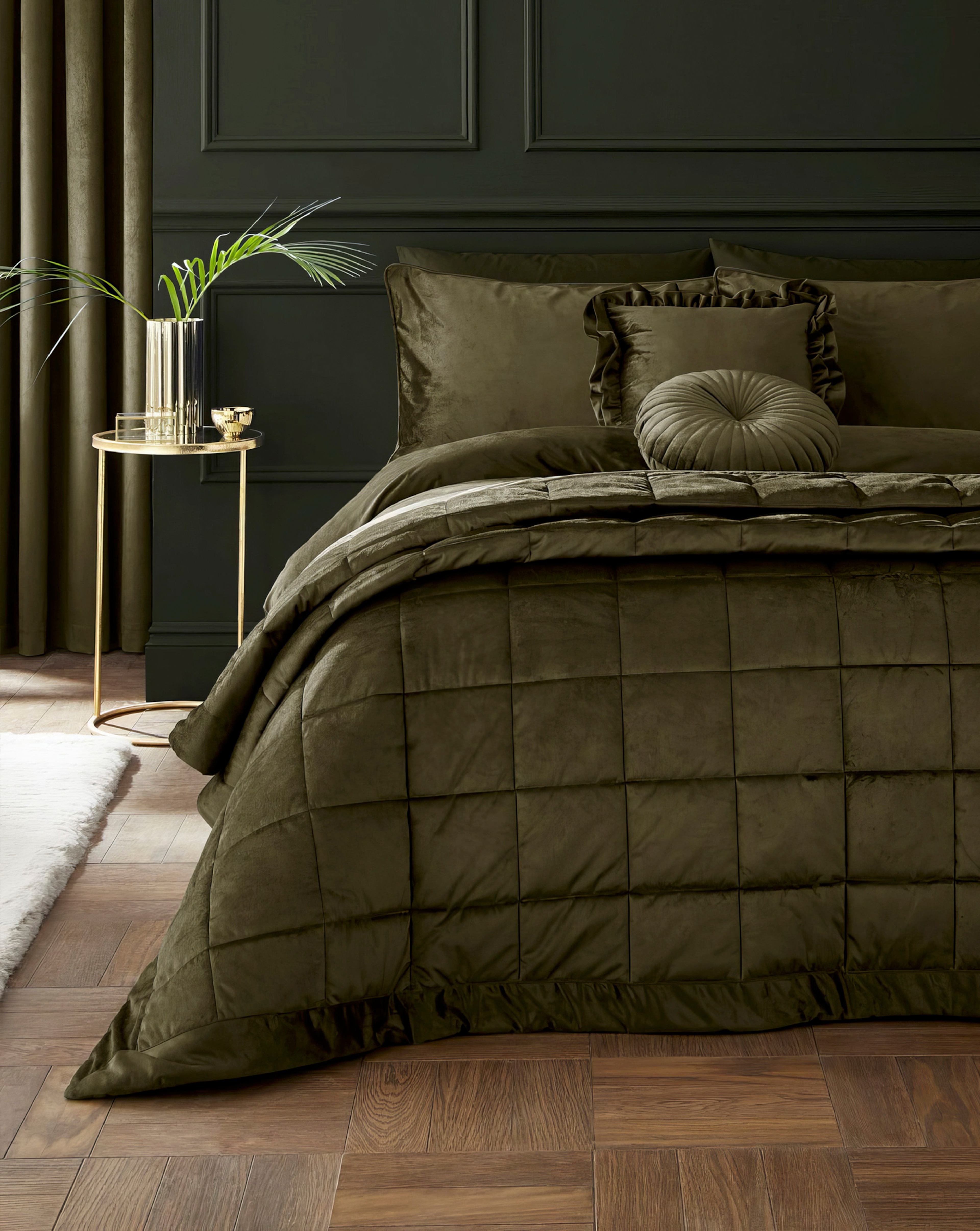 A green decorated bedroom with an olive green velvet bedspread