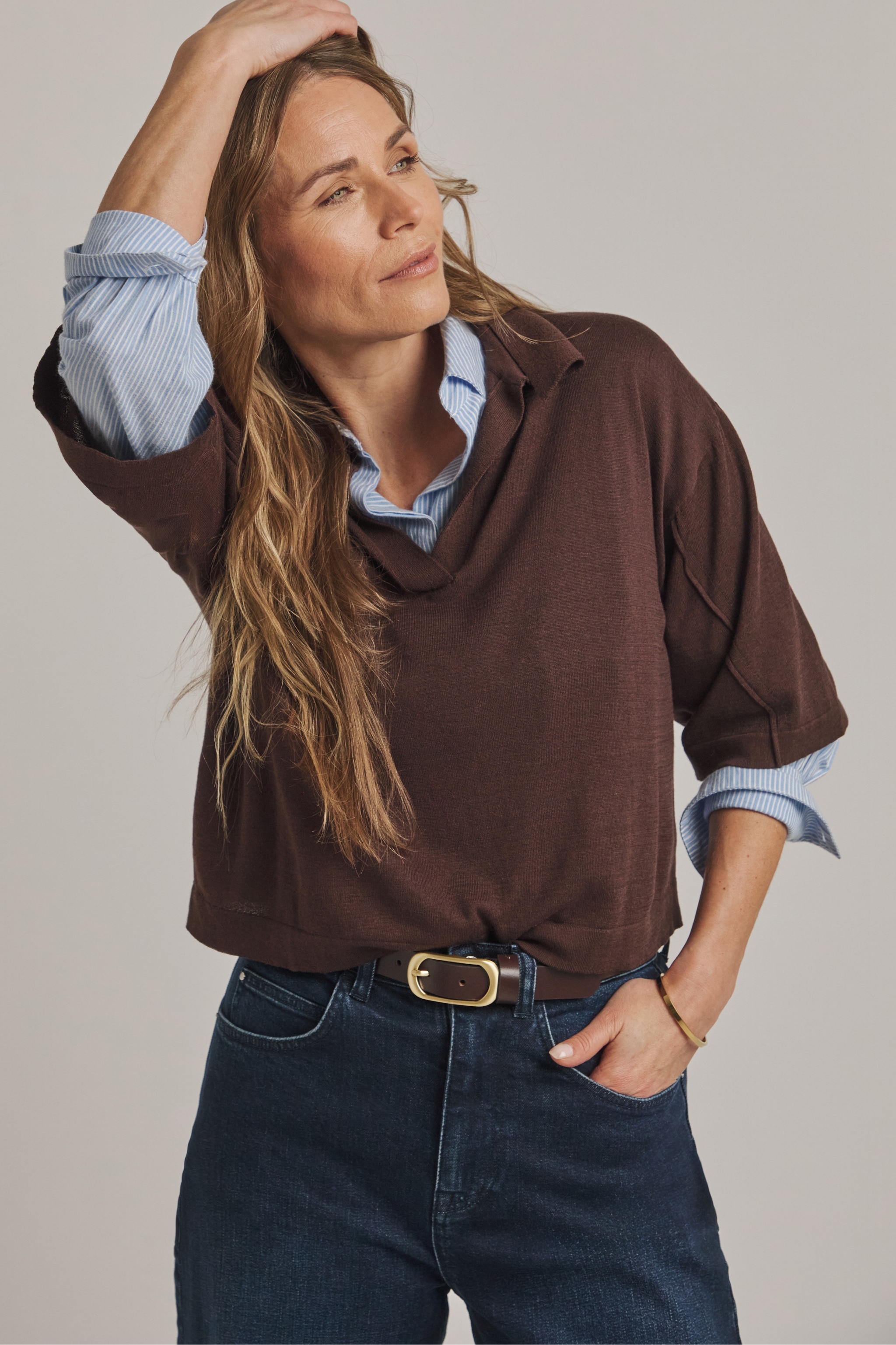 Woman wearing brown jumper and denim jeans