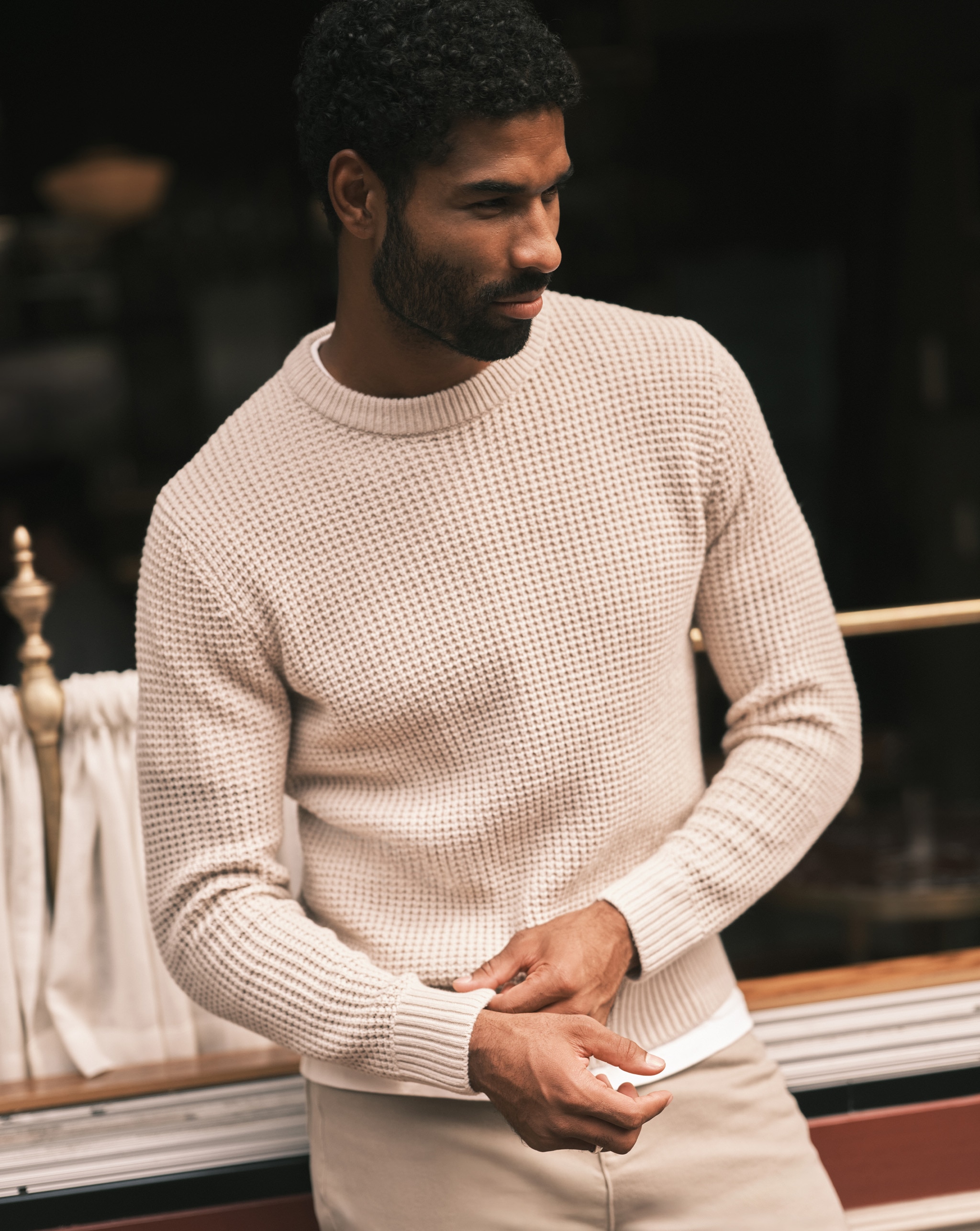 A person wearing a jumper looking to the right.