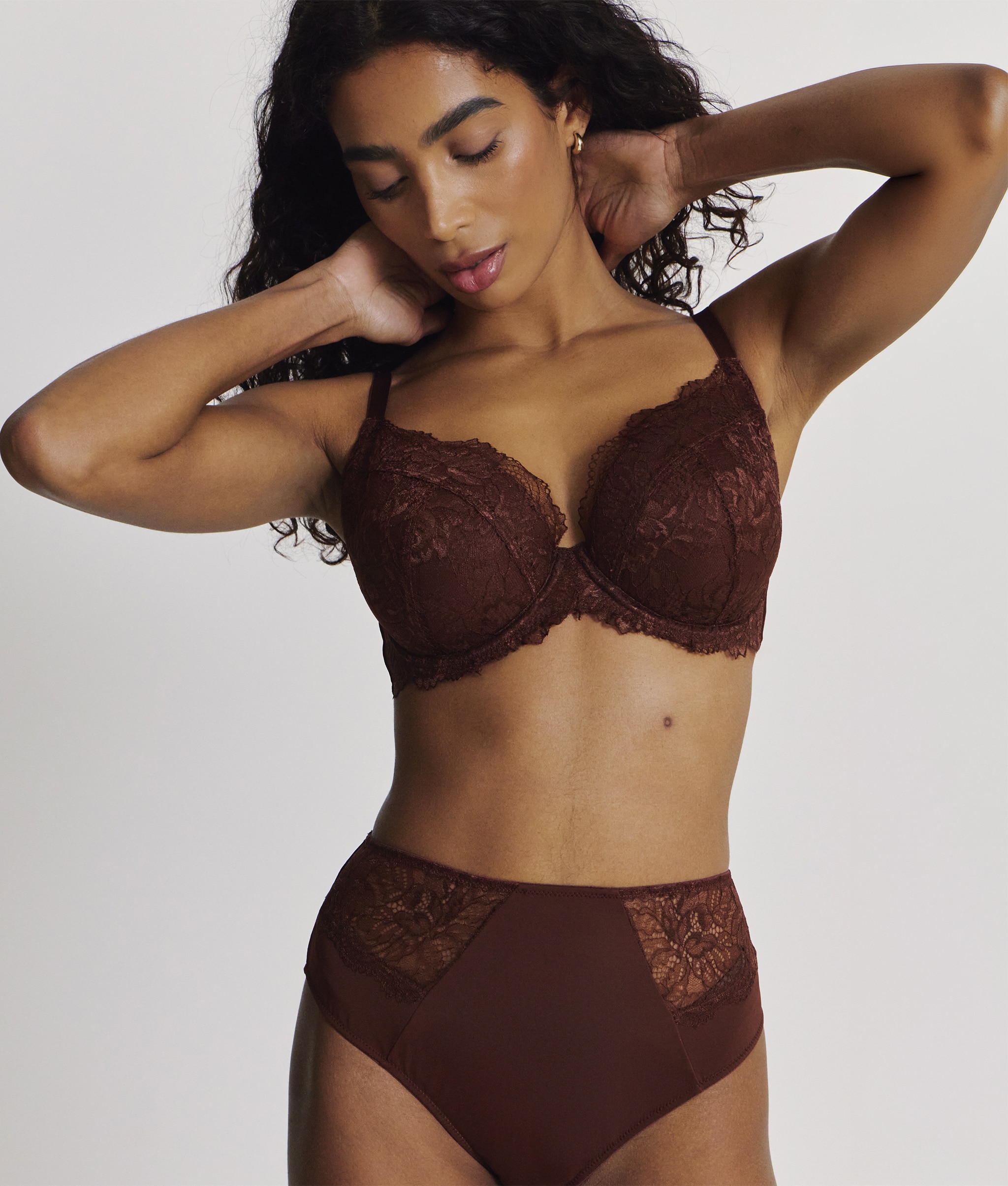 A woman stood up wearing matching chocolate colour lingerie